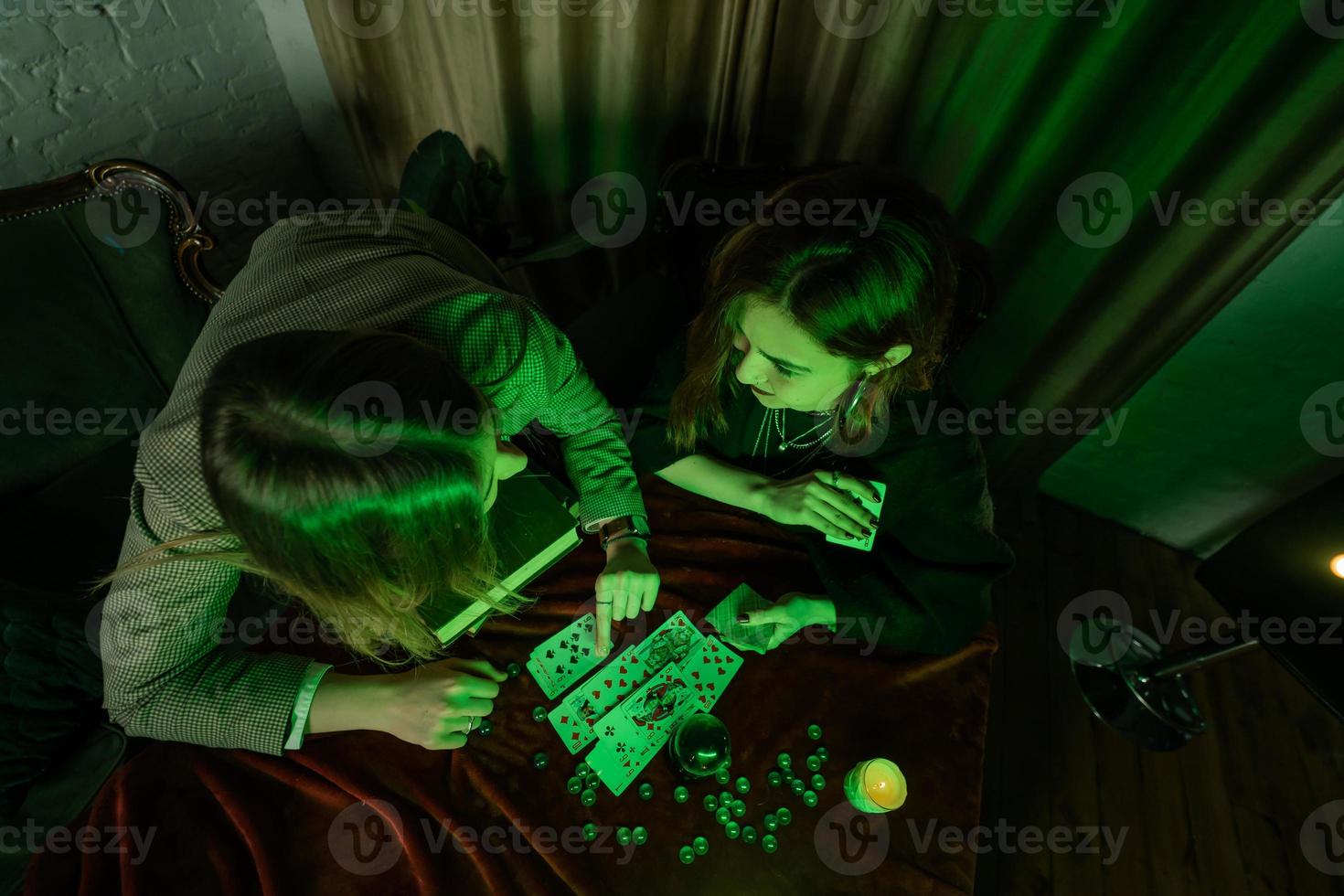 Fortune teller forecasting the future to woman with cards photo