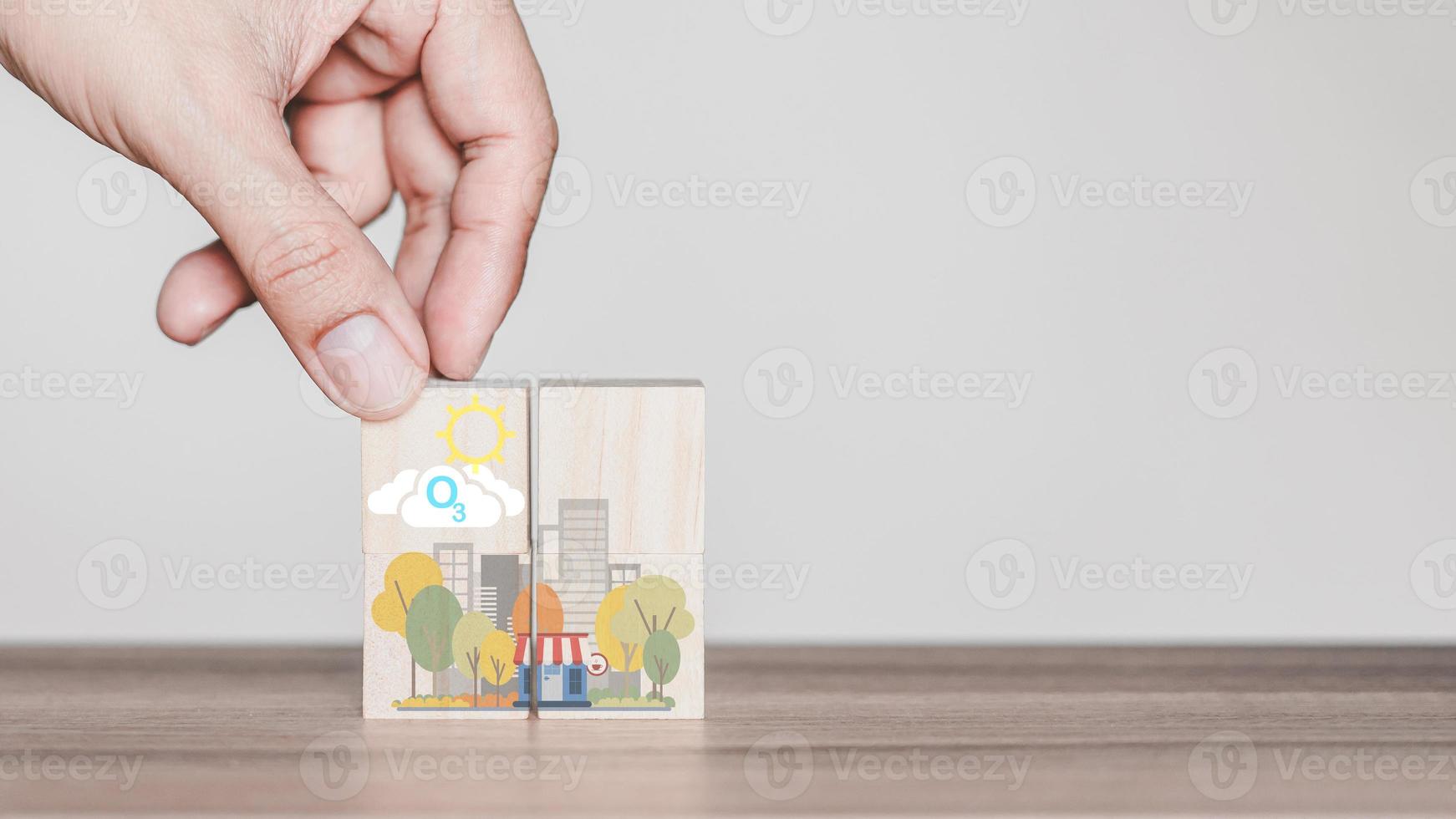 Hand holding with O3 chemical formula icon on wooden cube block with abstract cartoon city. Green office and urban concept. photo