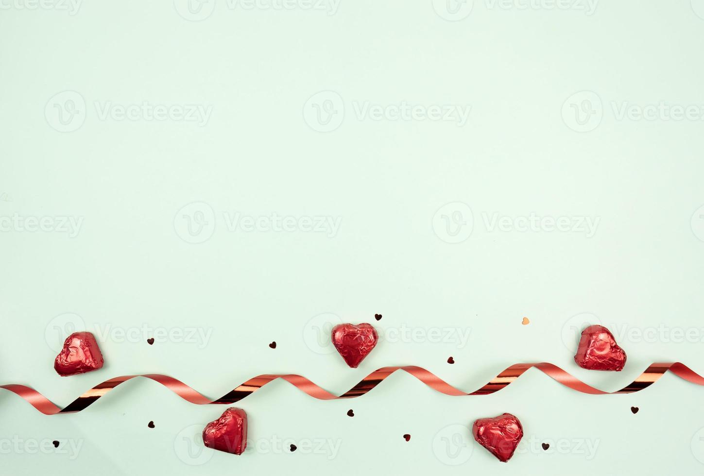 A festive flat lay of sweets in the form of the heart red ribbon and confetti. Copy space photo