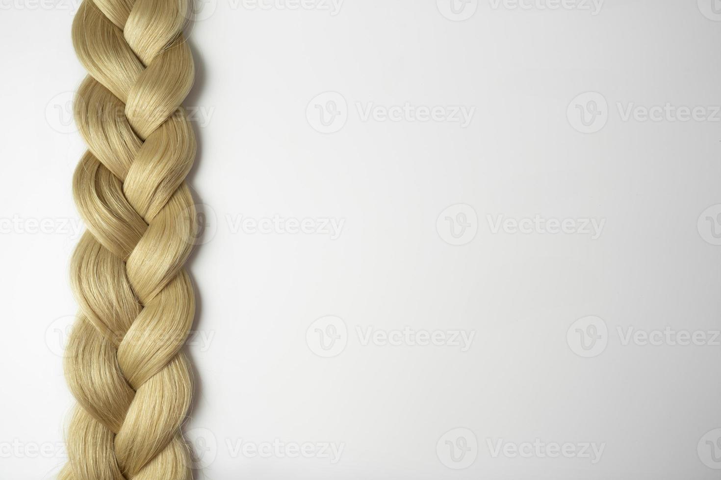 A blonde tress lying on a white background photo