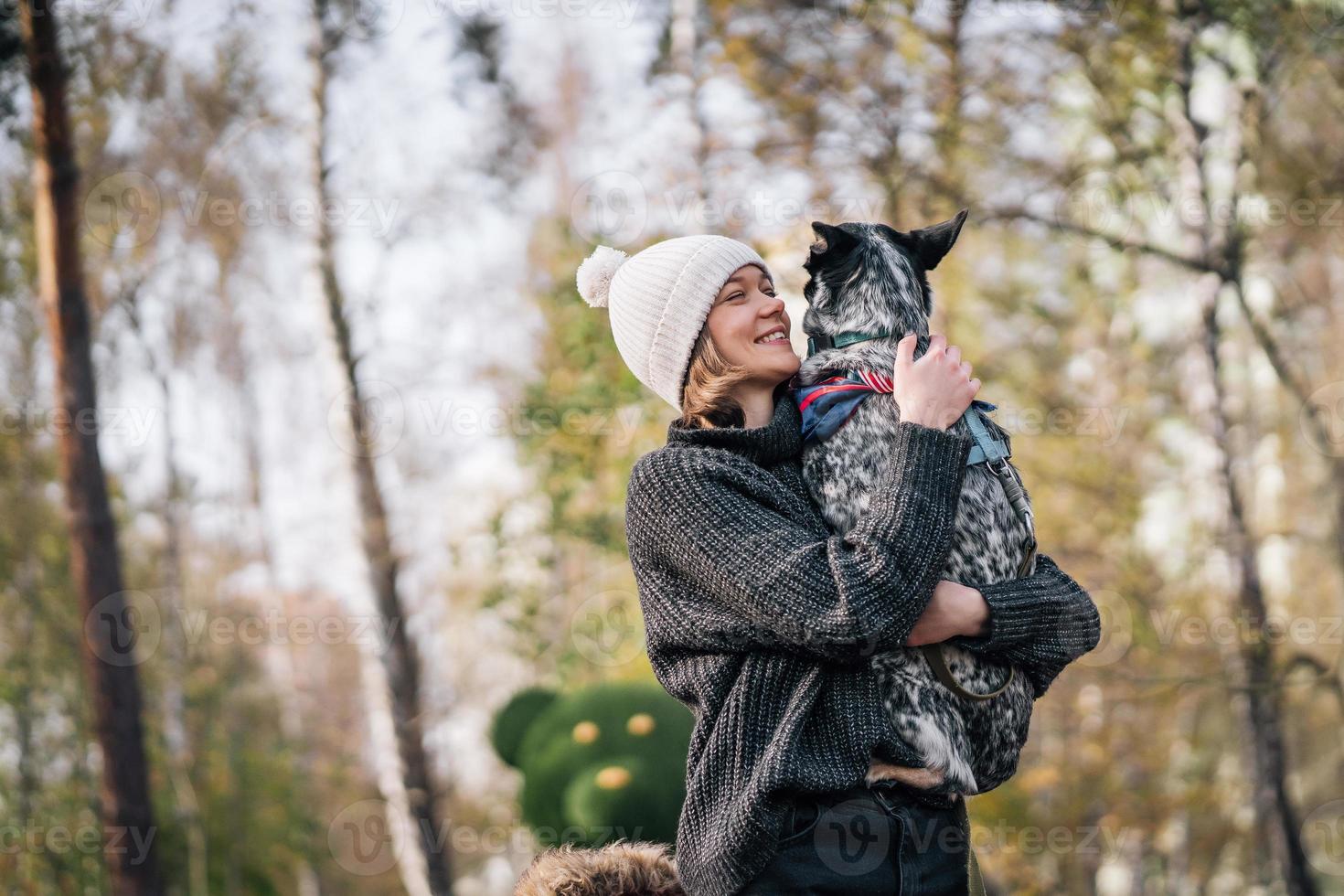 A girl is holding a mongrel dog in her arms. Caring for animals. photo