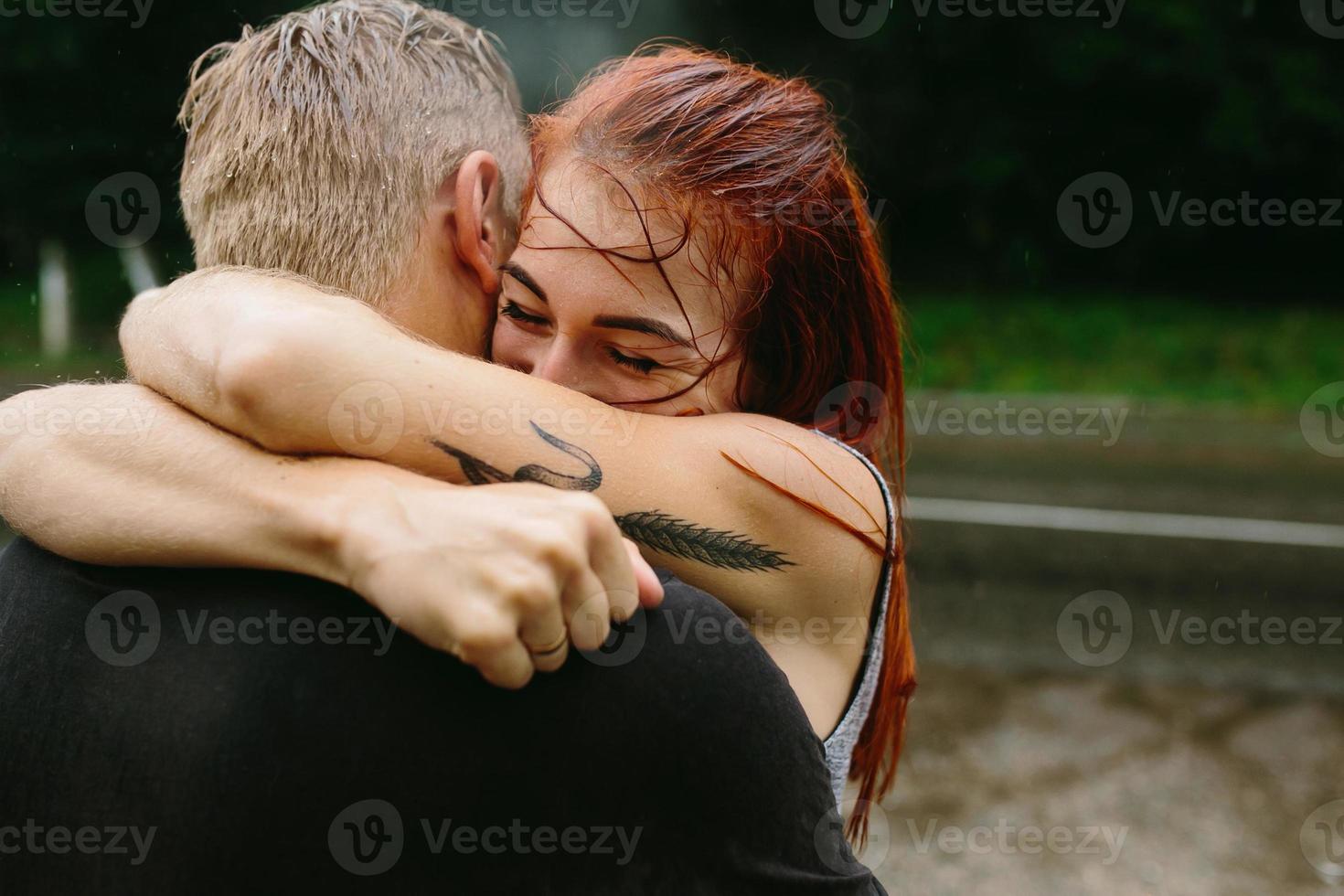 beautiful couple hugging in the rain photo