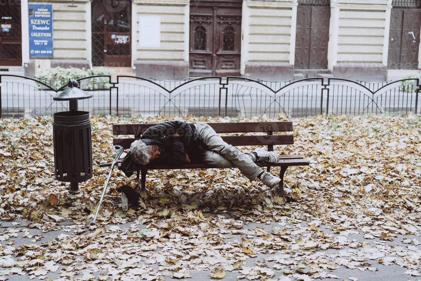 Homeless sleeping on the benches in the autumn park photo