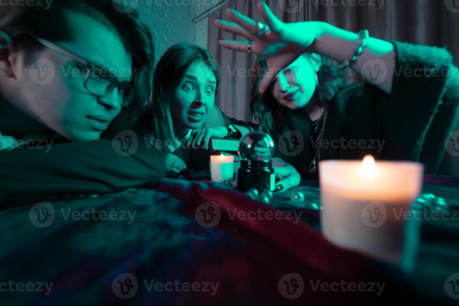 Group of people and woman fortune teller with crystal ball photo
