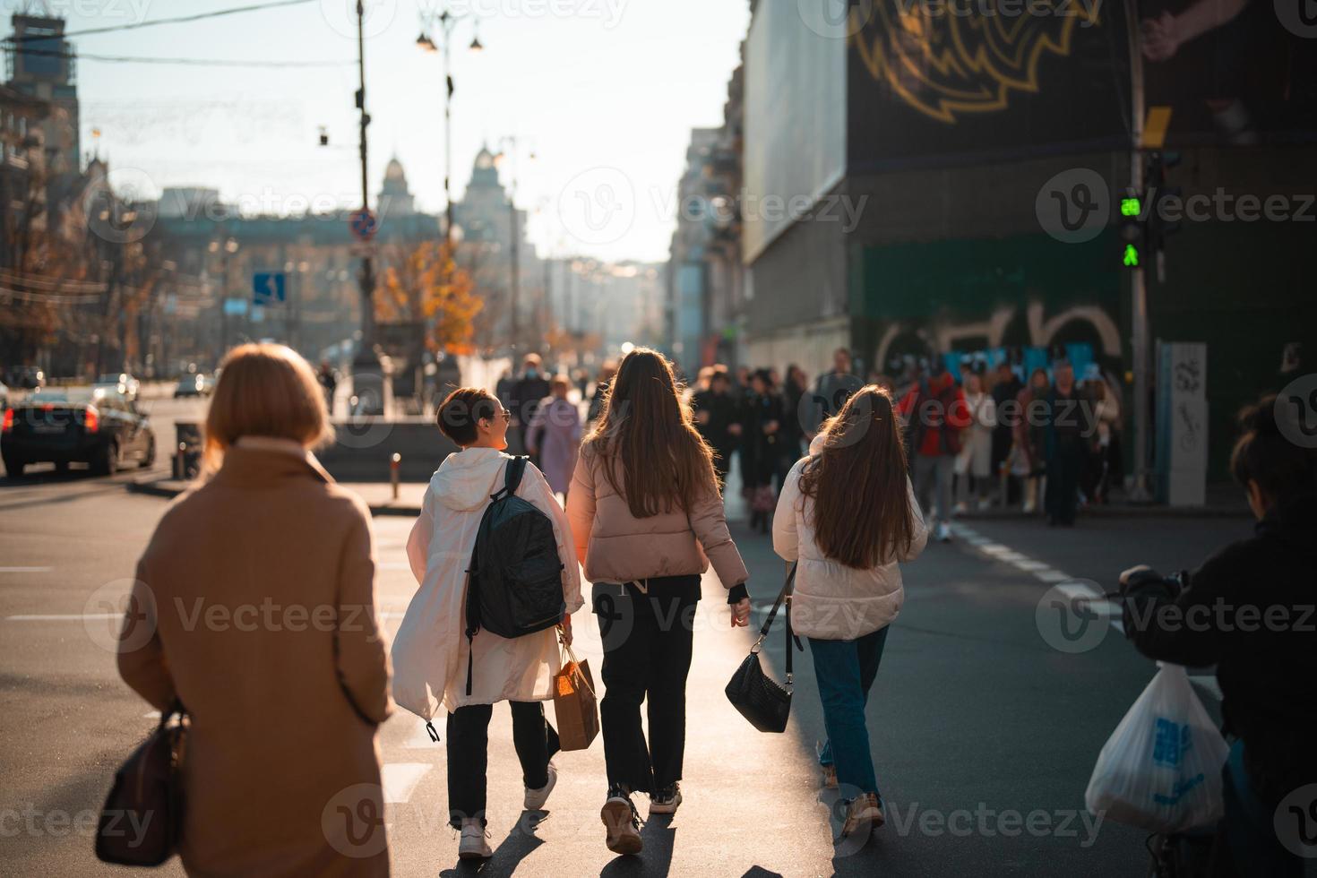 Lots of people crossing the street at the traffic lights. photo