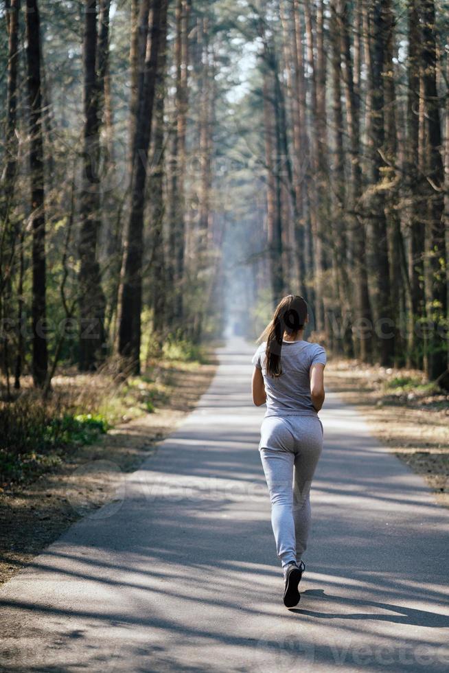 bella joven corriendo en un parque verde en un día soleado de verano foto