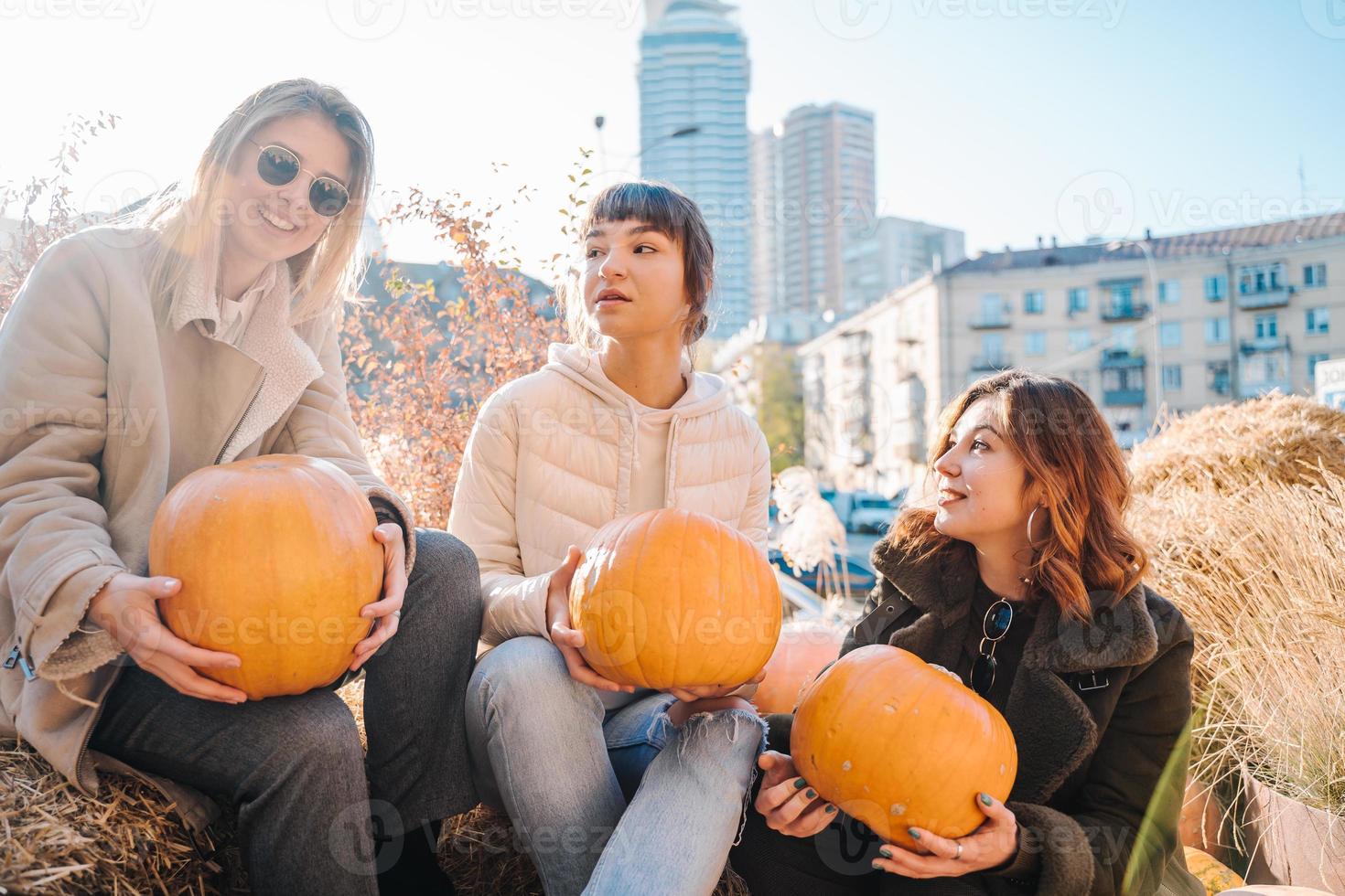 las niñas tienen calabazas en las manos en el fondo de la calle. foto