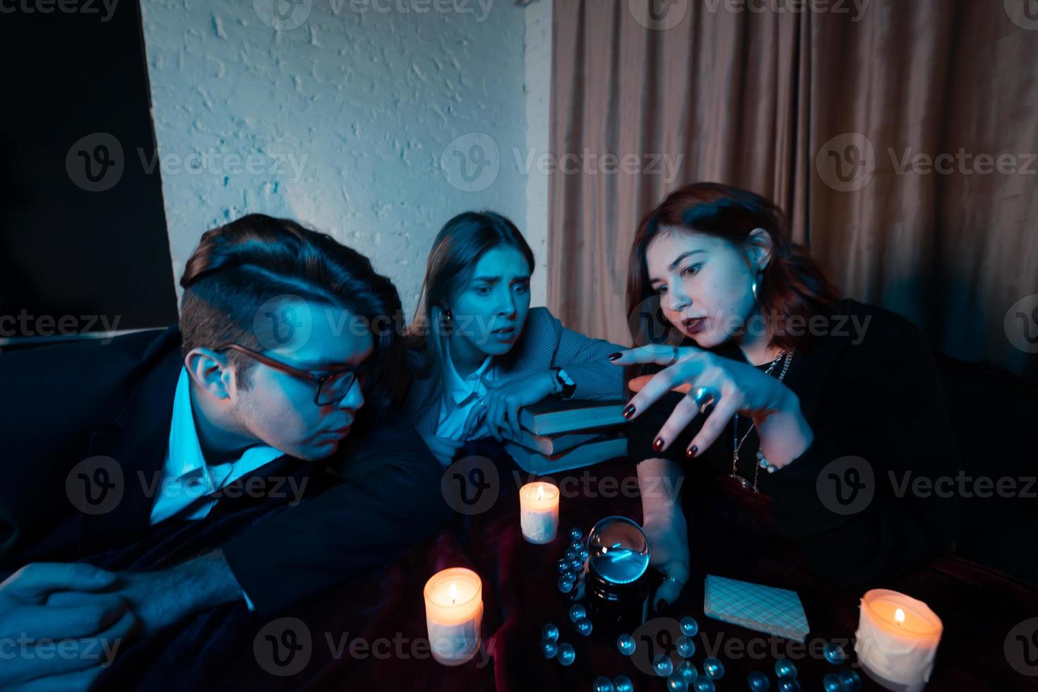 grupo de personas y mujer adivina con bola de cristal foto