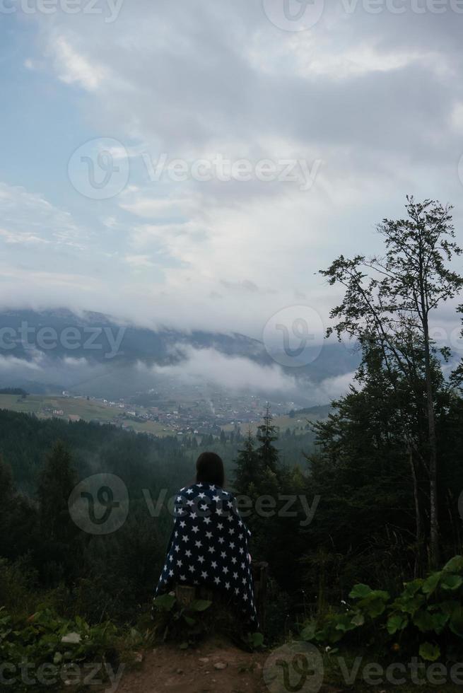 Woman on top of a hill, against the background of a valley photo