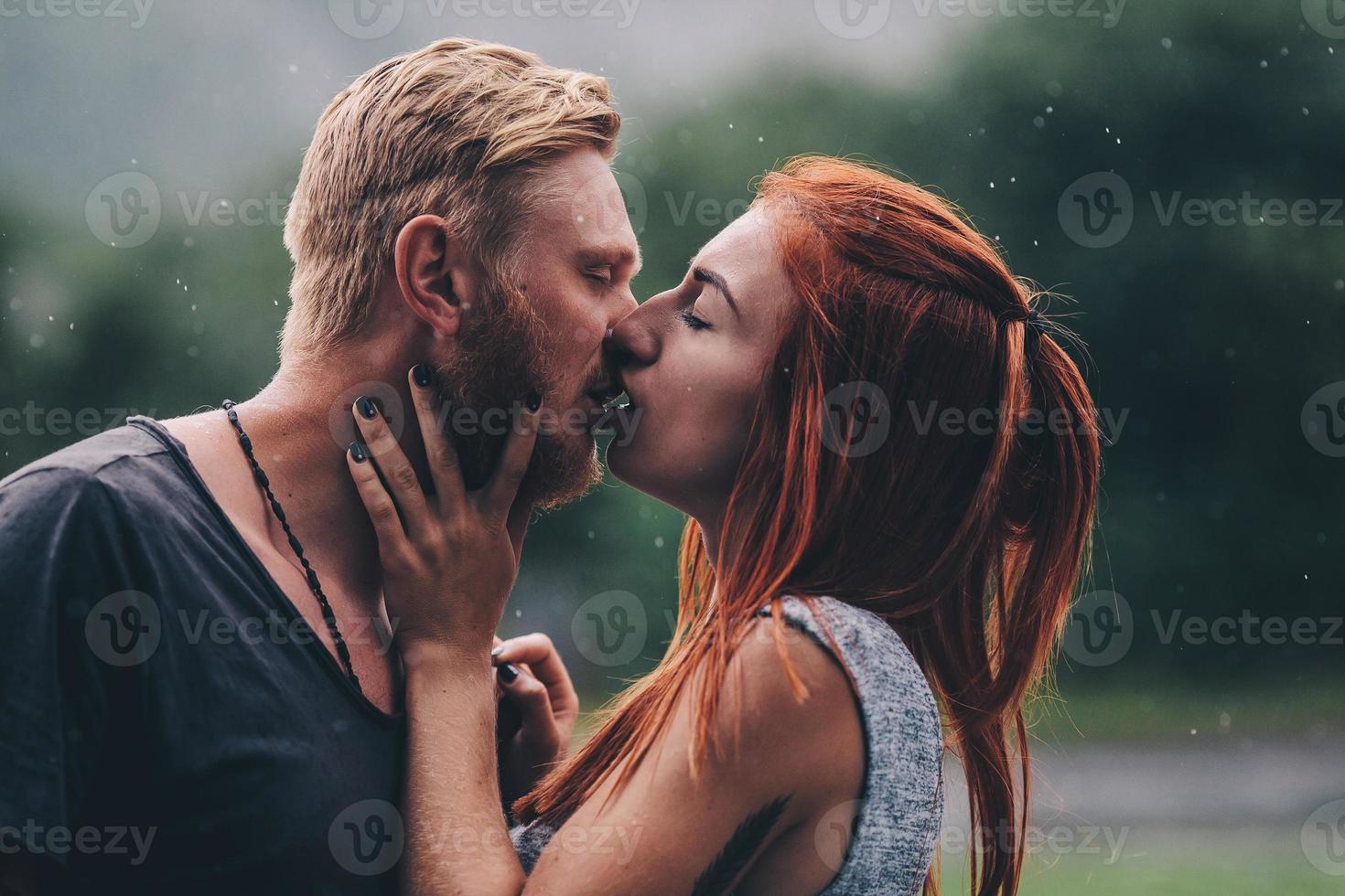 beautiful couple kissing in the rain photo