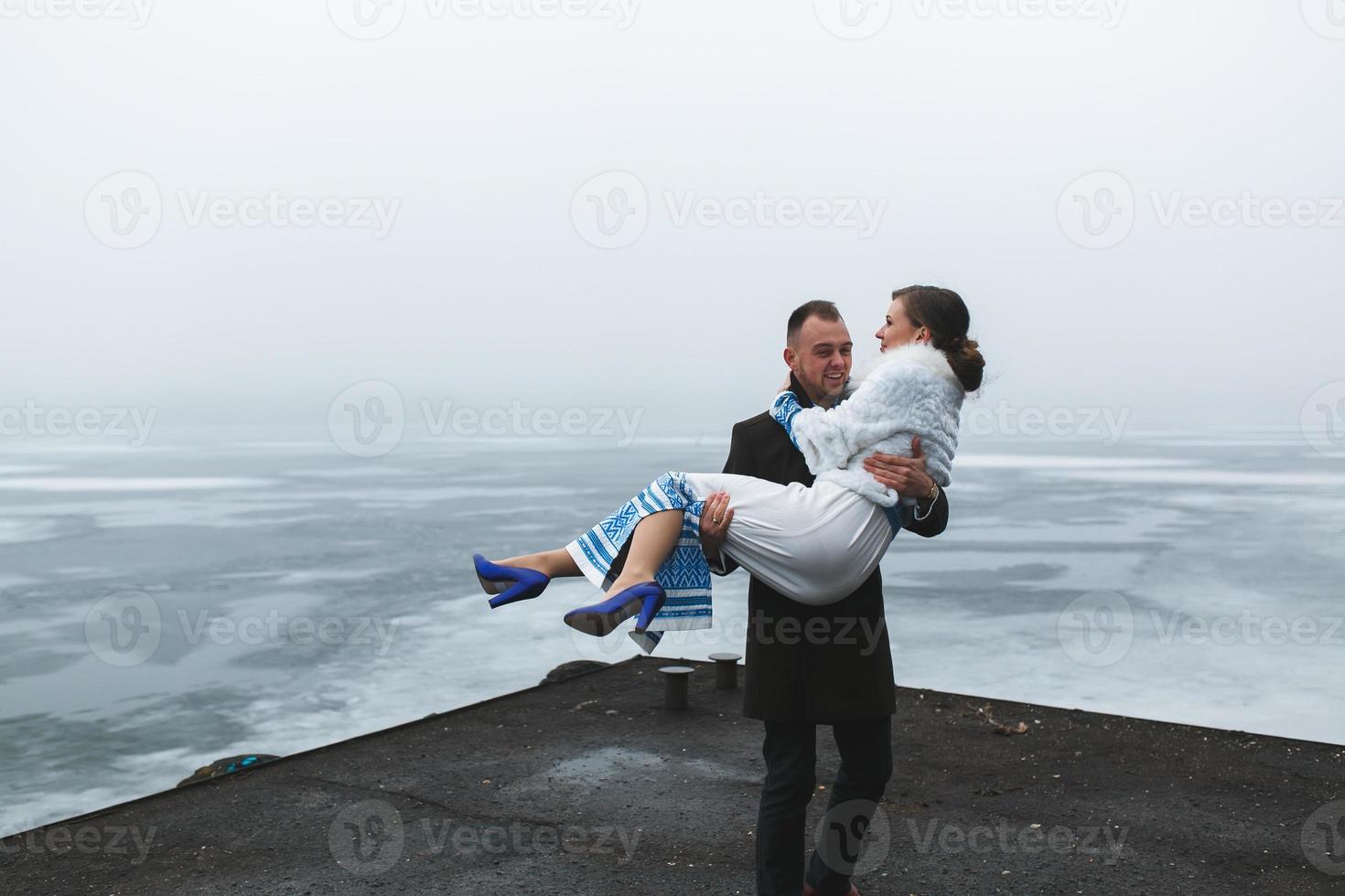 Beautiful couple on the dock in the winter fog. photo