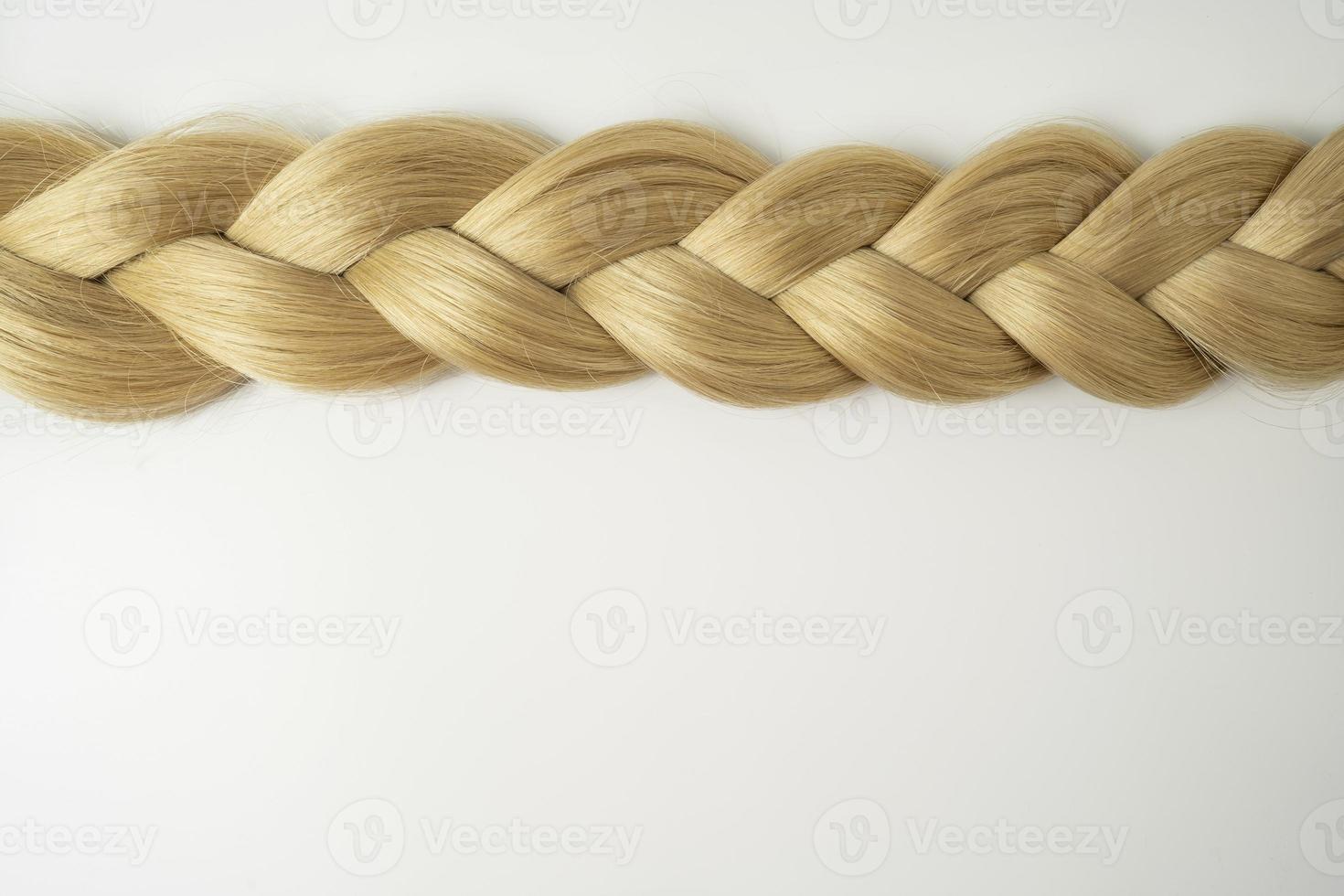 A blonde tress lying on a white background photo