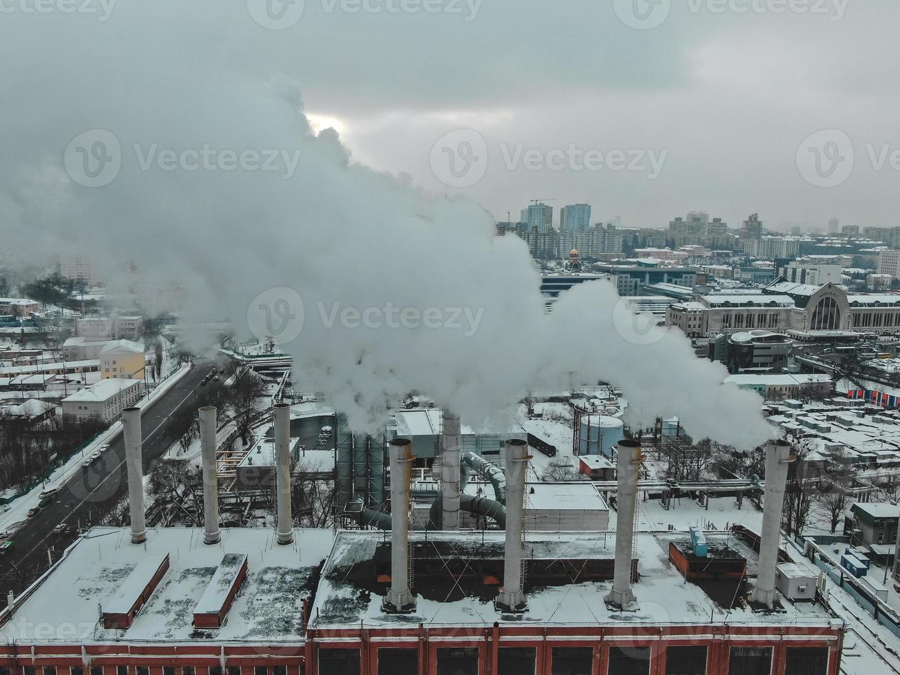 Large central boiler room with giant pipes of which there is dangerous smoke in winter during frost in a big city photo