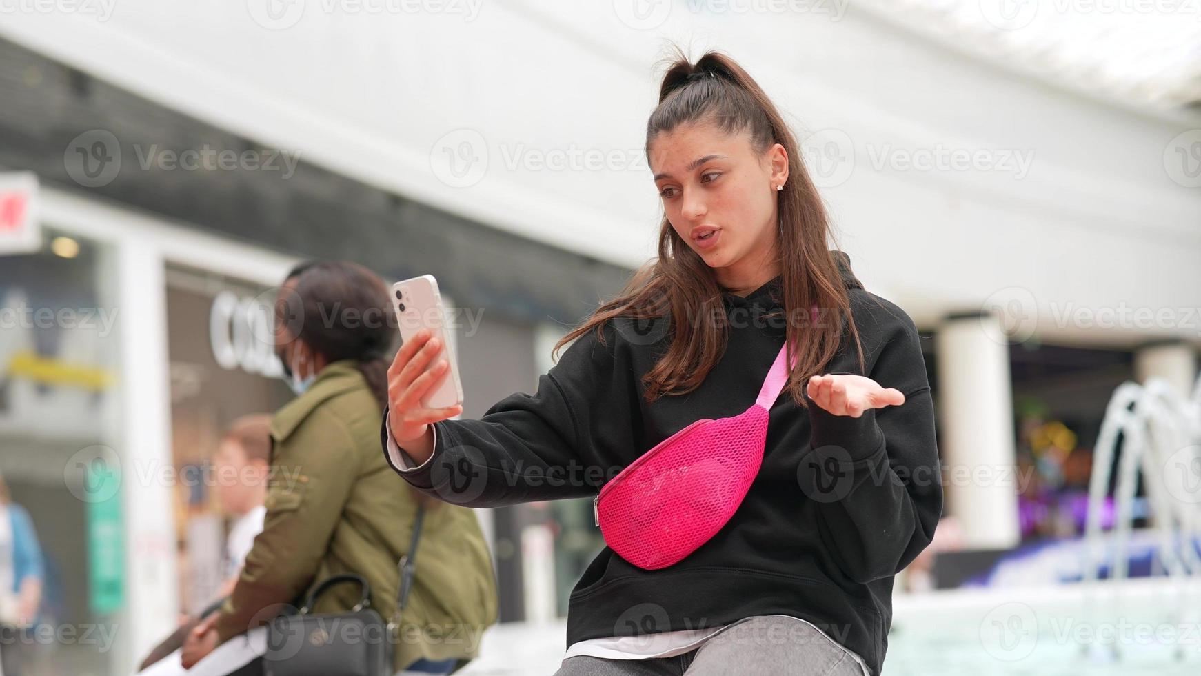 Woman using smartphone indoor. Texting and communicating in mall photo