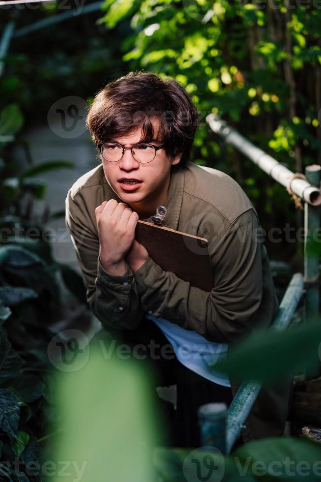 Male scientist hiding in the thicket. Nature protection and wildlife preservation concept. photo