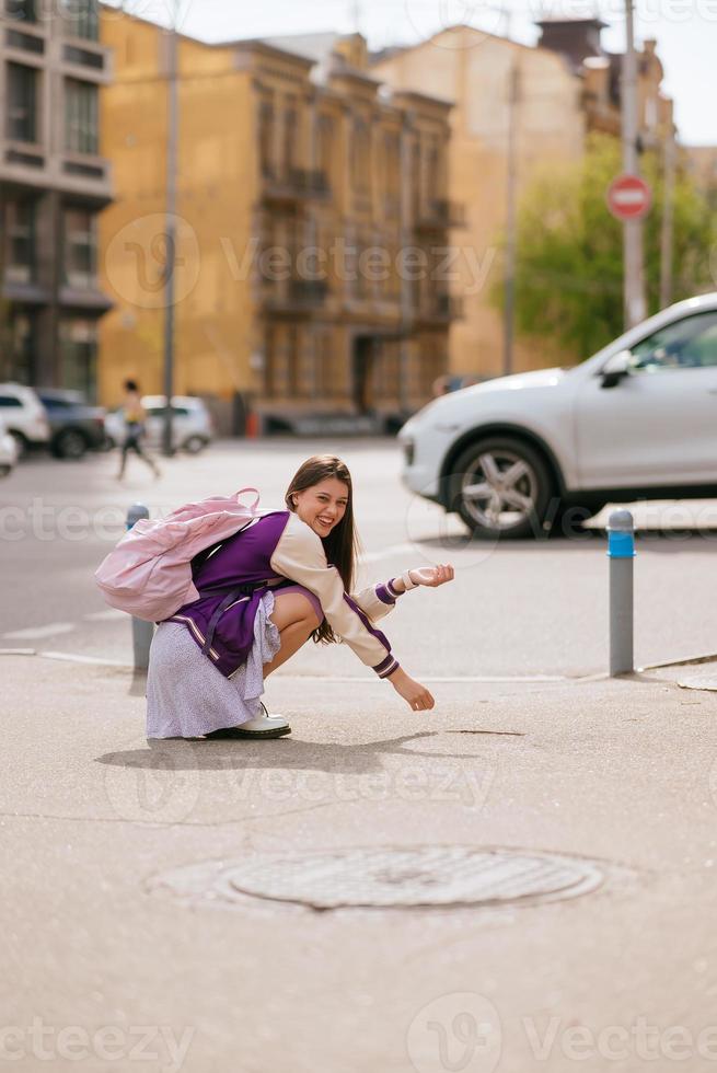Young beautiful woman sitting in the middle of the sidewalk photo