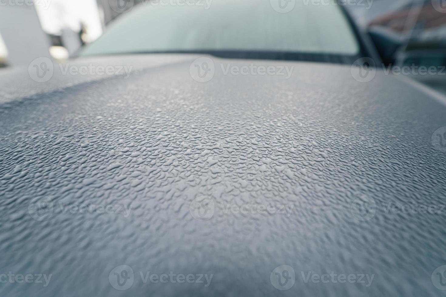Raindrops on the hood of the car. Close-up. photo