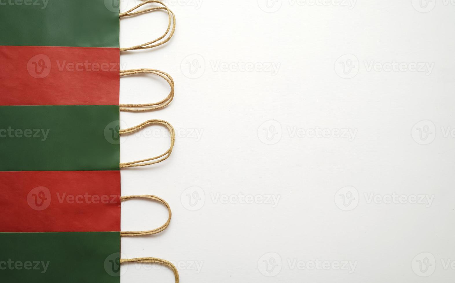 A row of colourful paper shopping bags lying on a white background photo