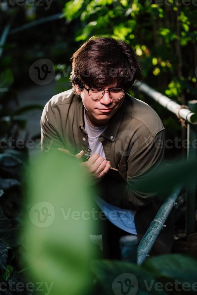 Male scientist hiding in the thicket. Nature protection and wildlife preservation concept. photo