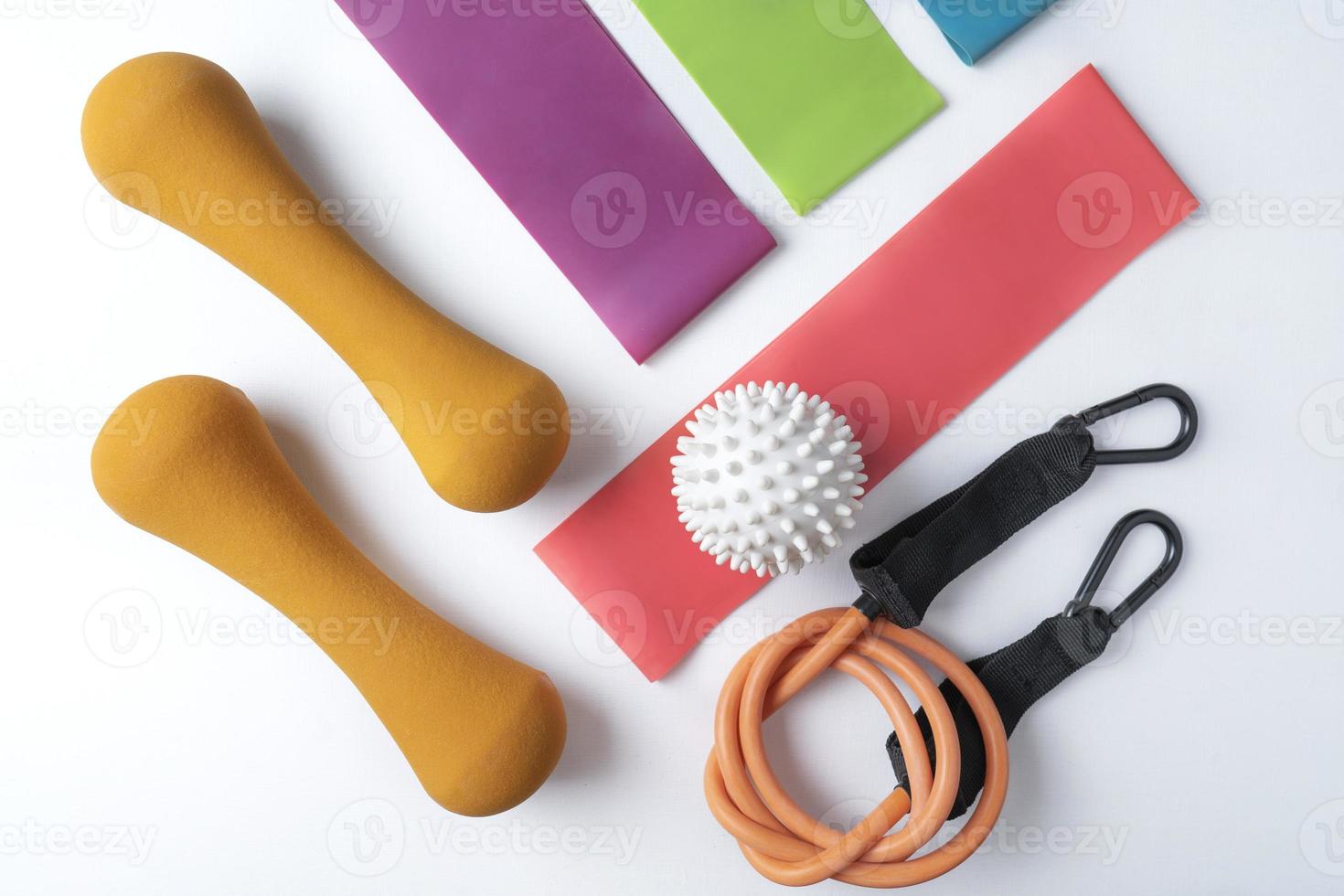 Different colourful equipment for fitnes and sport exercises balls, bands and expanders lying on a white background photo