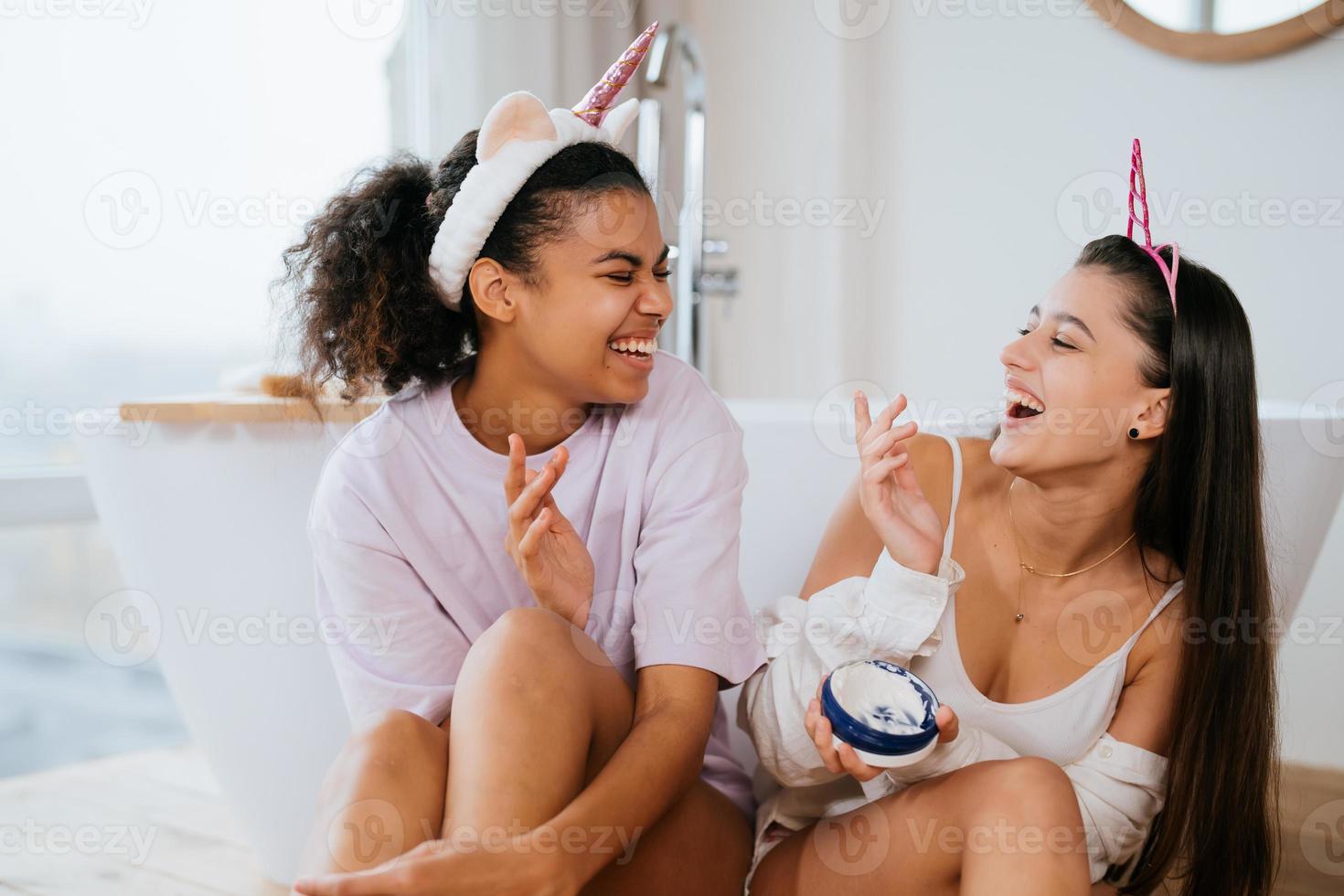 Two girls in the bath playing with face cream photo