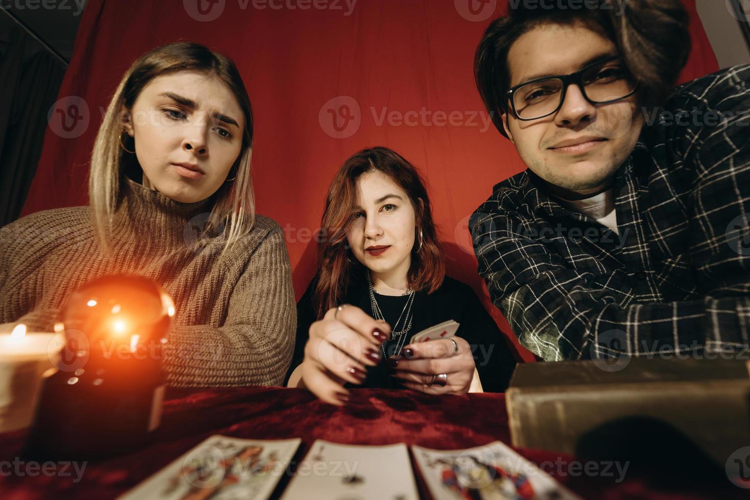 Group of people and woman fortune teller with crystal ball photo