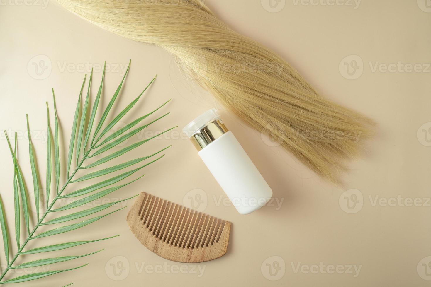 Blond hair and a hair serum and comb for extention lying on a beige background photo