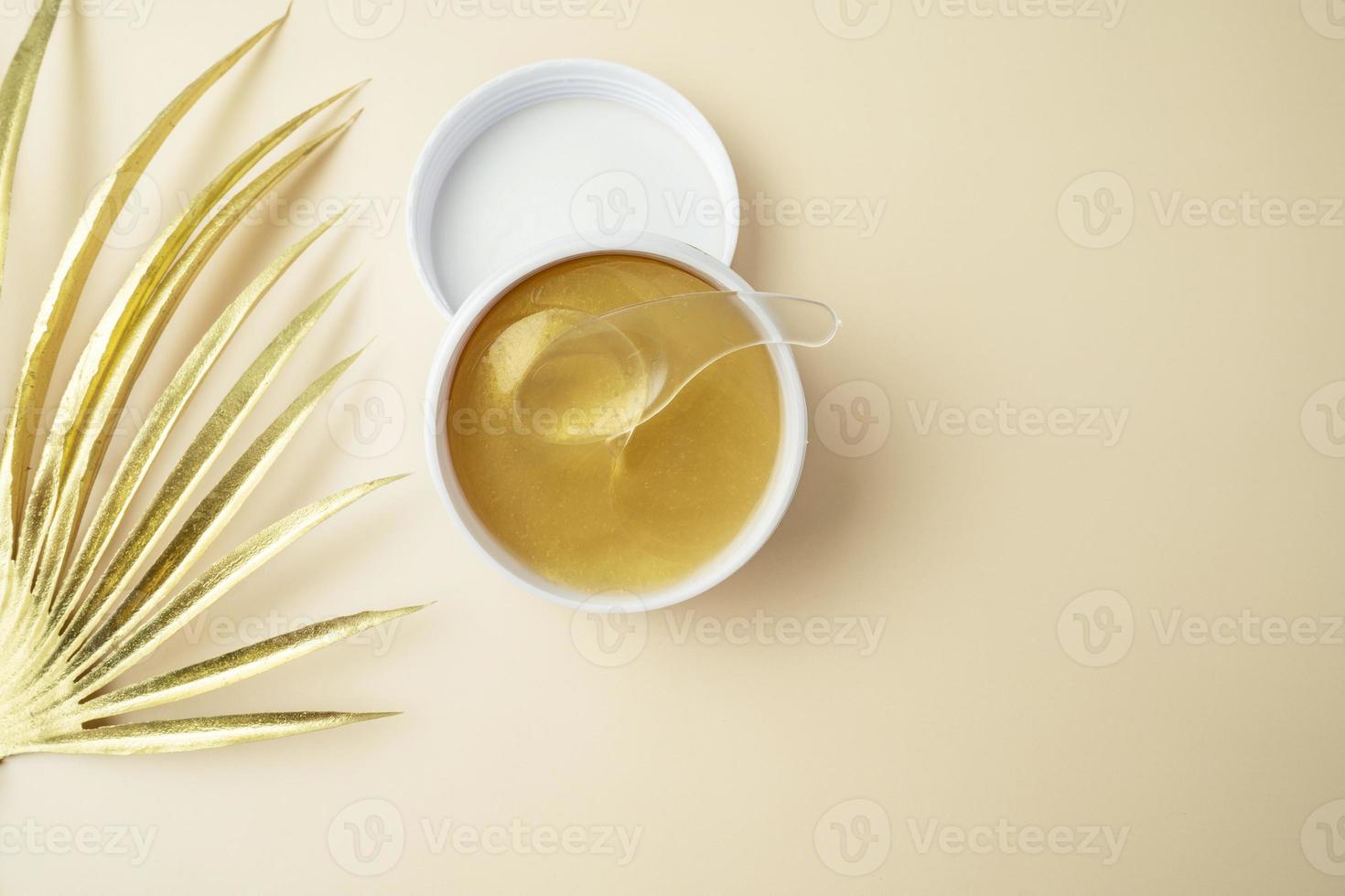 A white box of golden patches with snail standing on the beige background photo