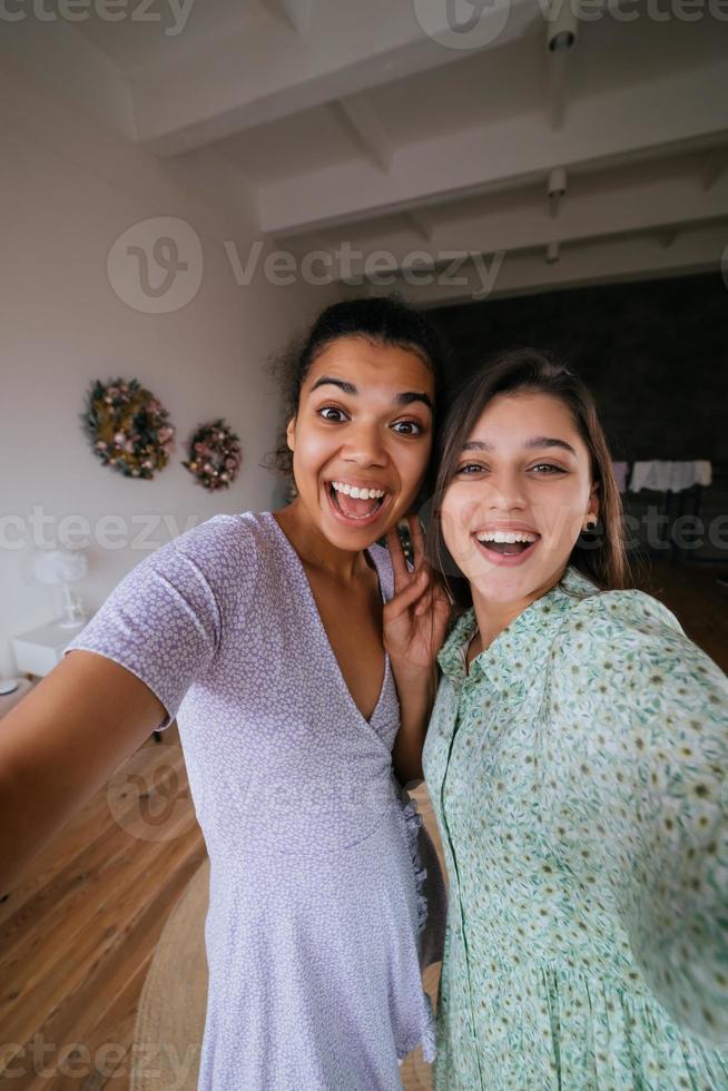 dos chicas toman selfies en la sala de estar foto