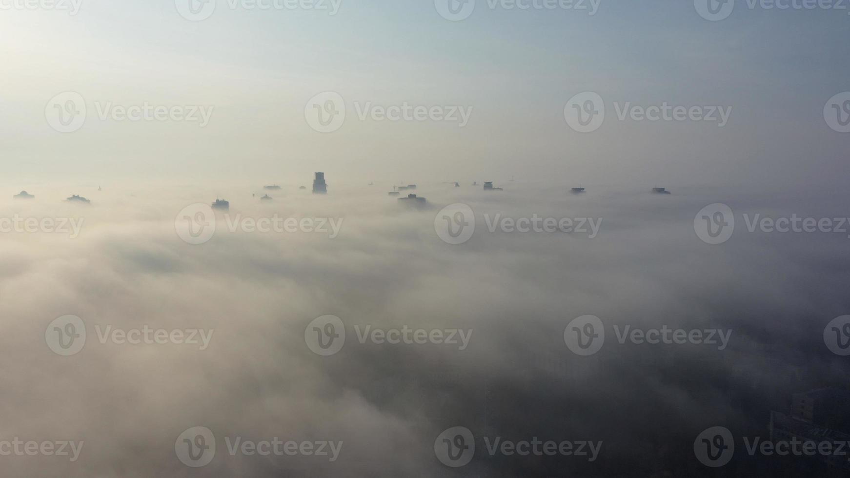 Aerial view of the city in the fog. Skyscrapers above the fog photo