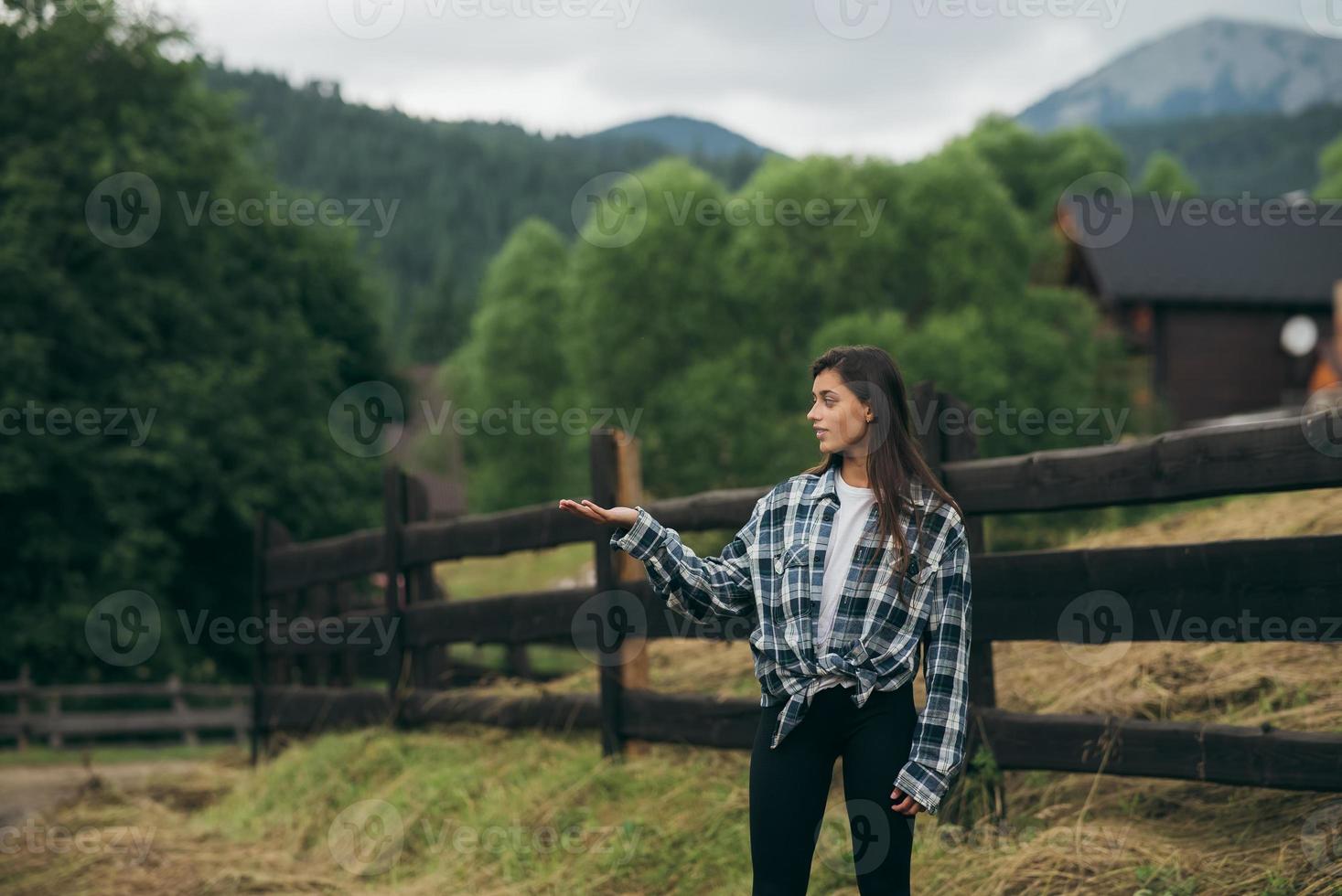 A young attractive Caucasian female sitting on a fence photo