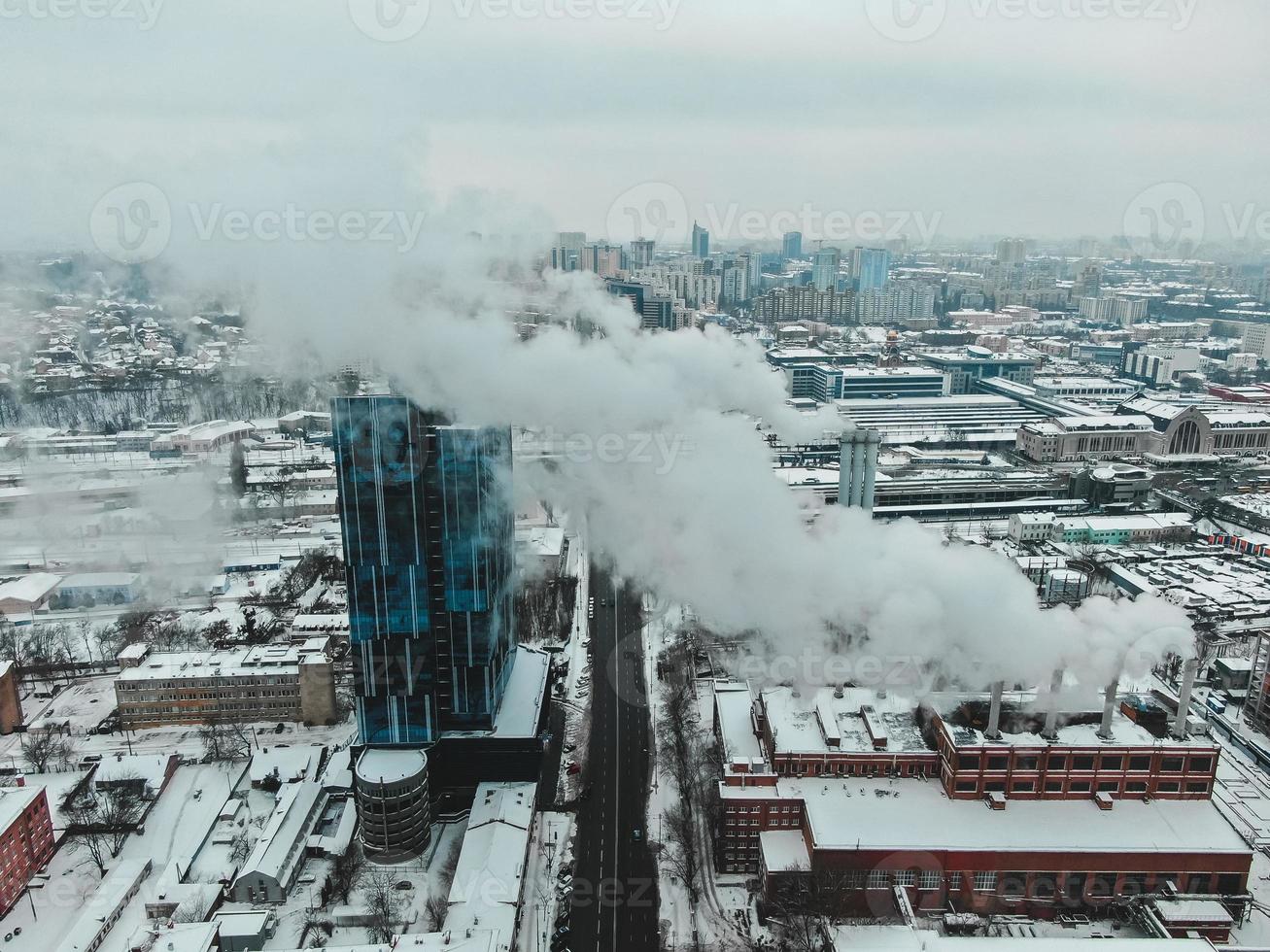 Large central boiler room with giant pipes of which there is dangerous smoke in winter during frost in a big city photo