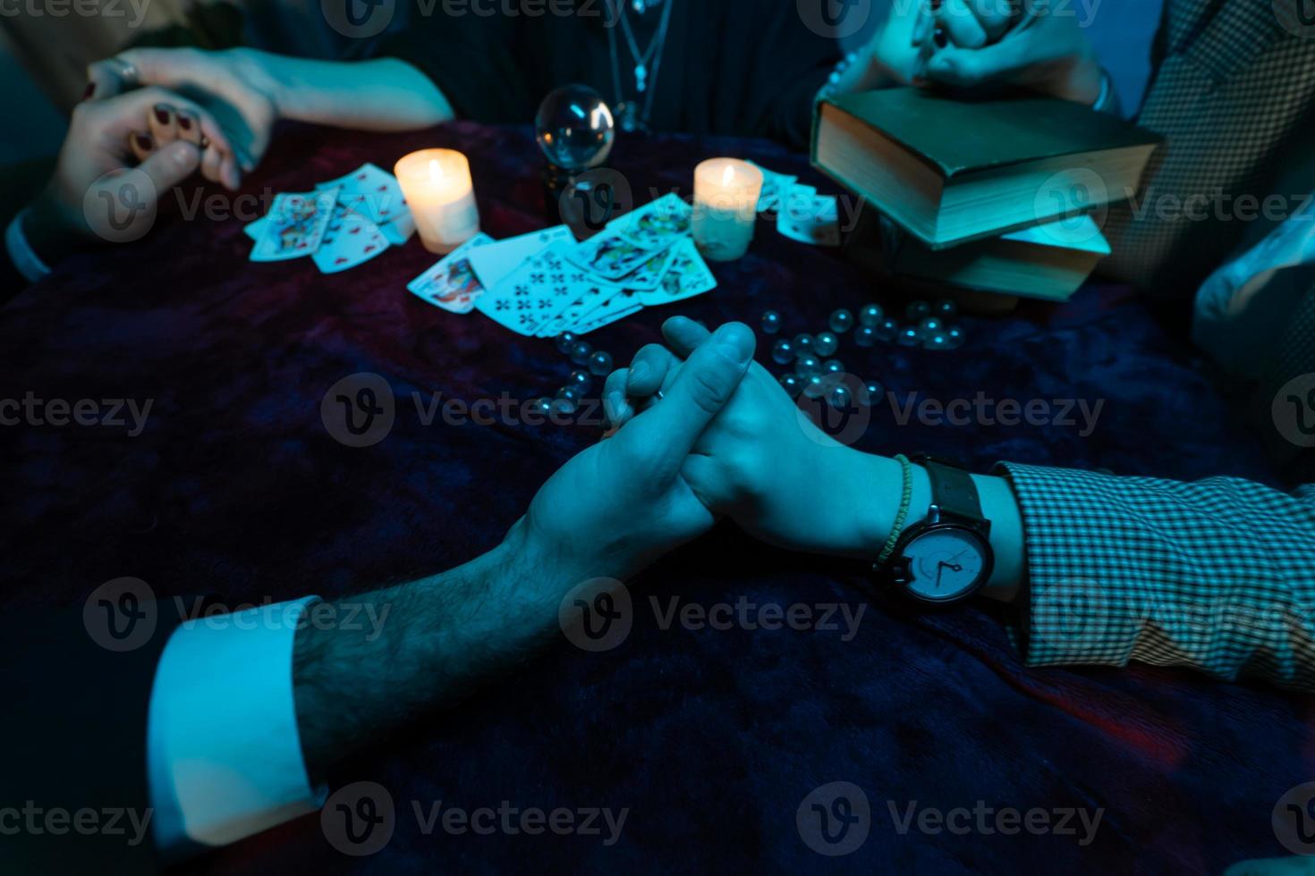 la gente se da la mano de la noche en la mesa con velas foto