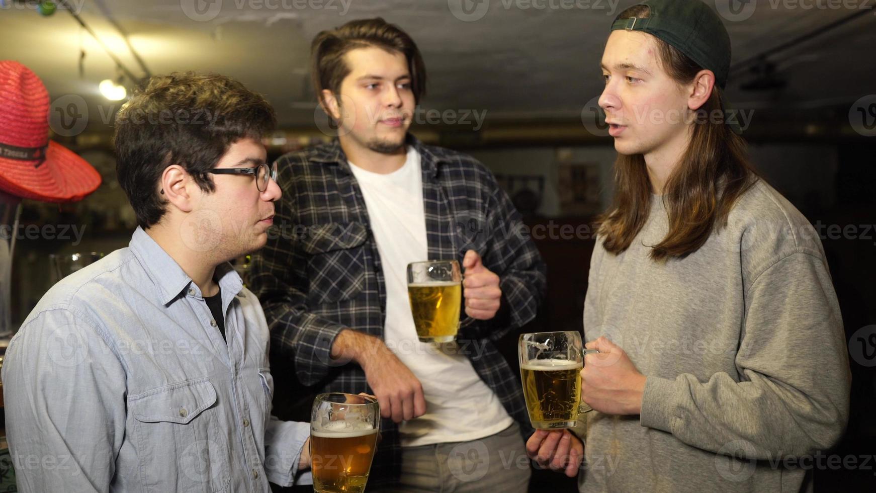 Young friends having fun together drinking beer in a pub. photo