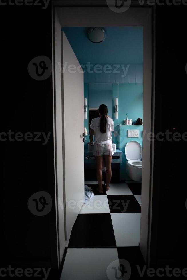 Back view of pretty young woman in front of mirror, selective focus. photo
