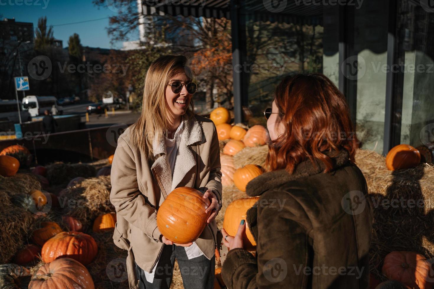 Girls holds pumpkins in hands. Outdoor photo. photo