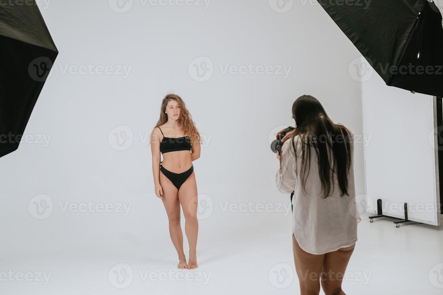 Professional male photographer taking pictures of woman model photo