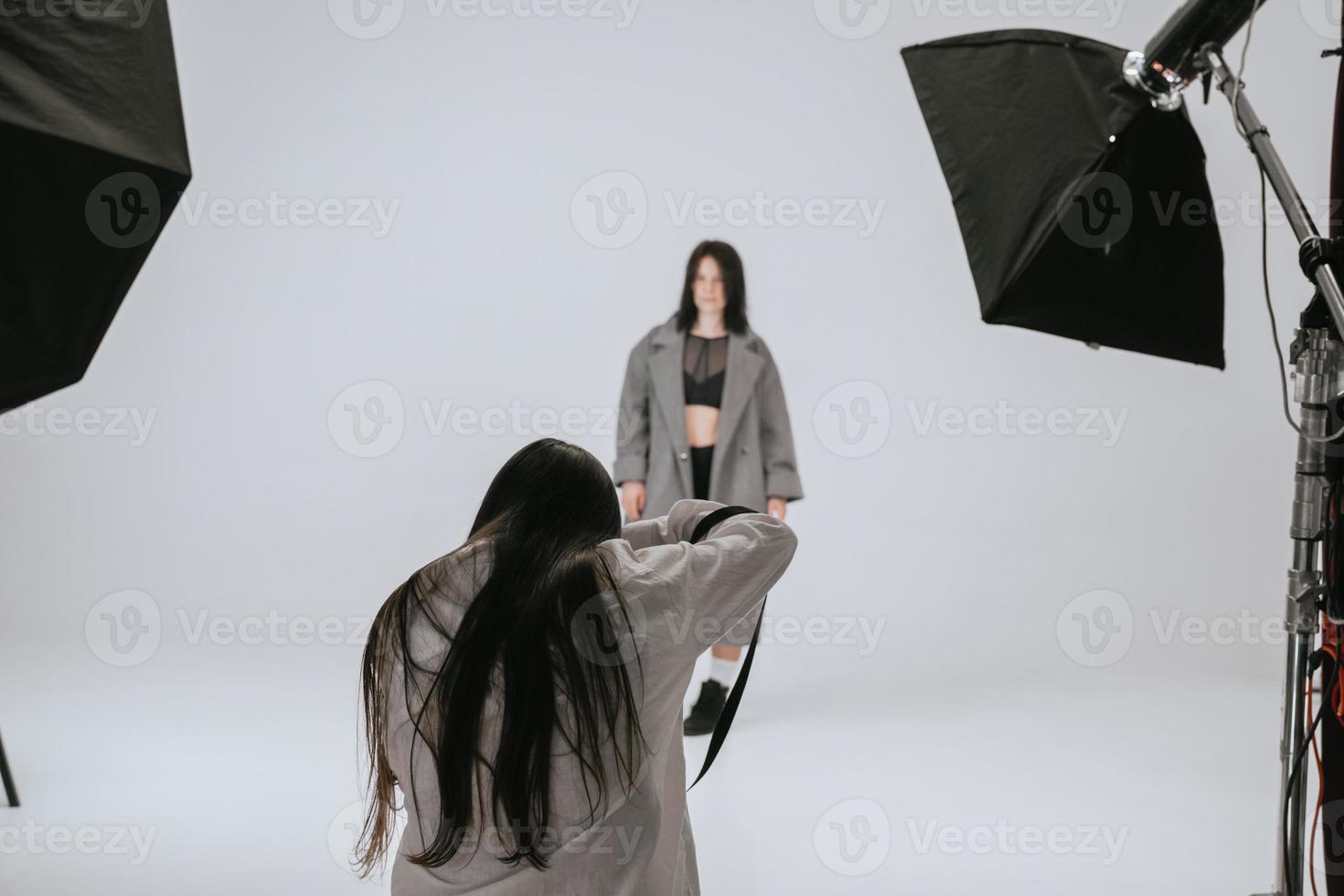 Professional male photographer taking pictures of woman model photo