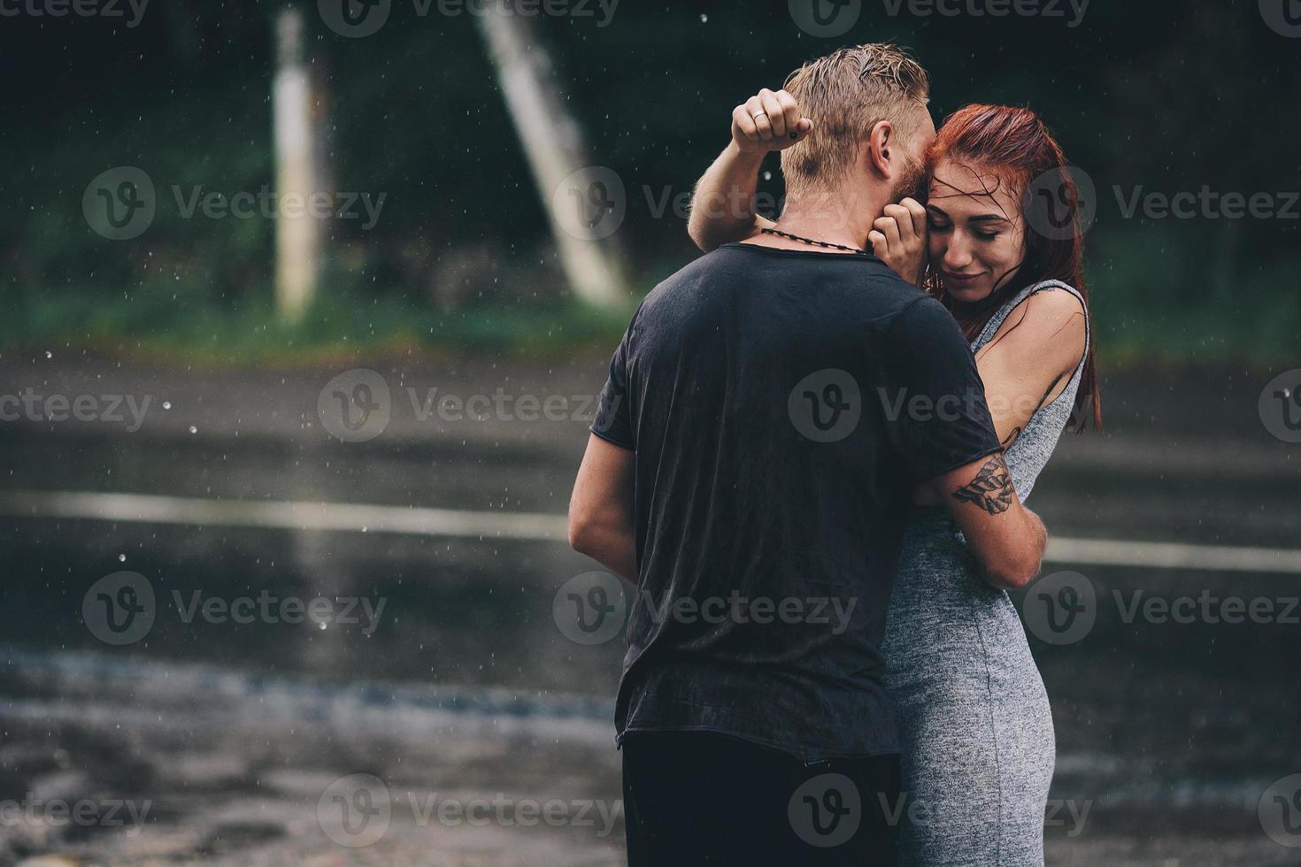 beautiful couple hugging in the rain photo