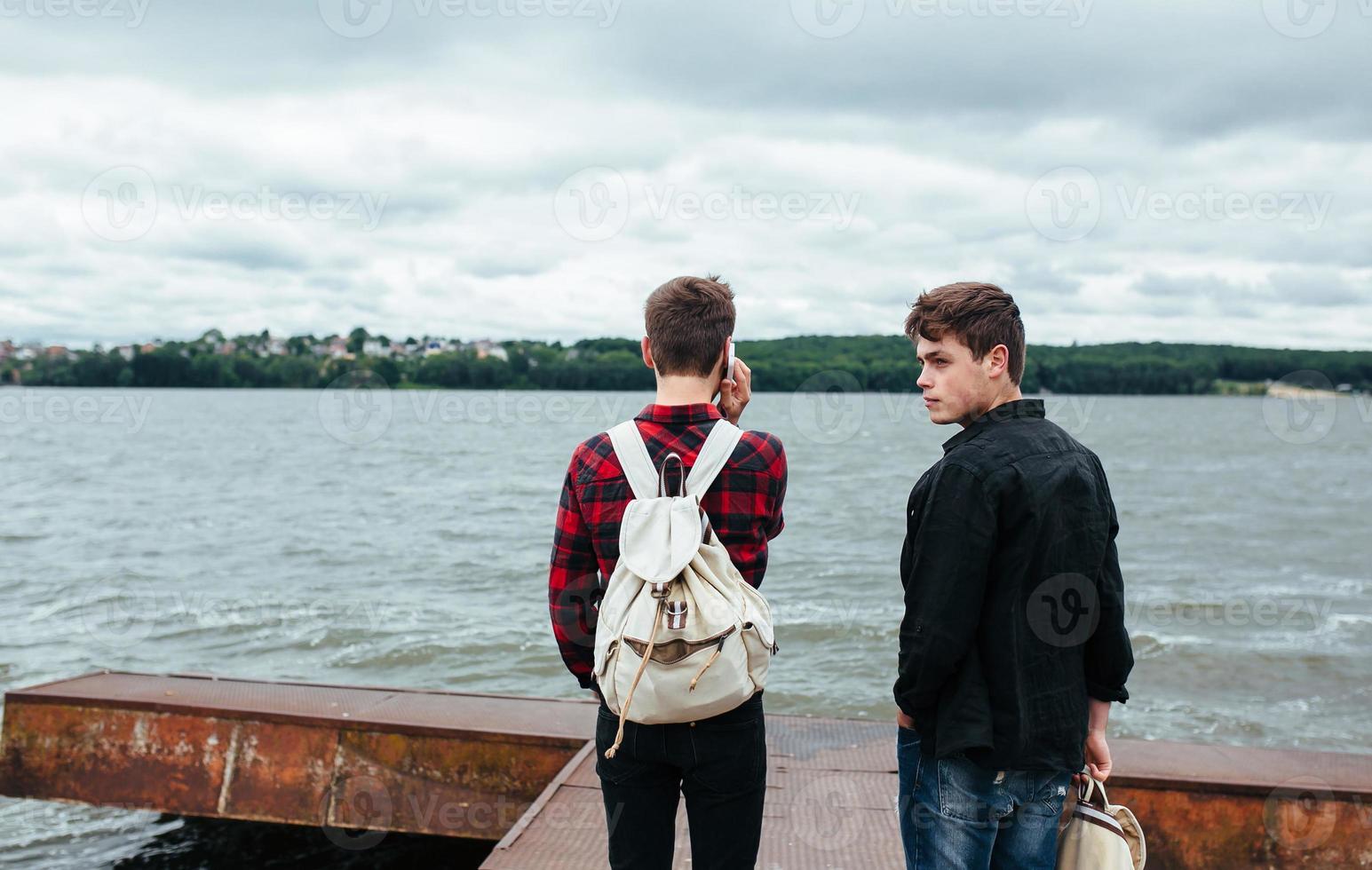 two young guys stand on the pier photo