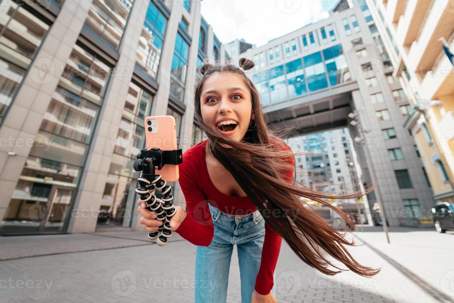 Beautiful female blogger looking at the camera on the street. photo