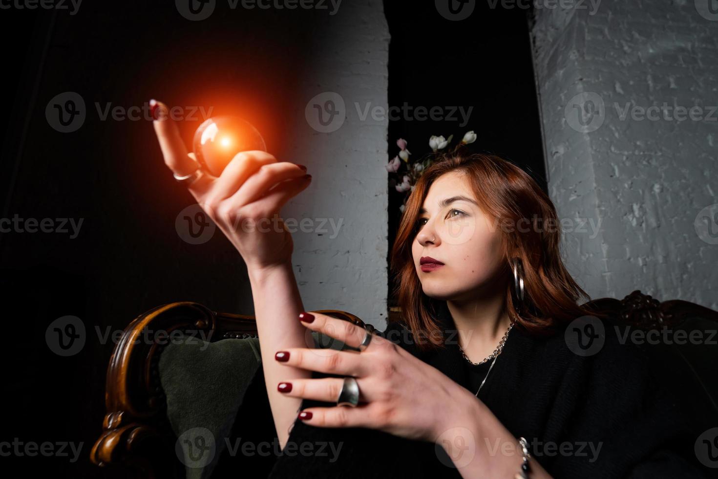 Woman in black suit holding crystal ball photo