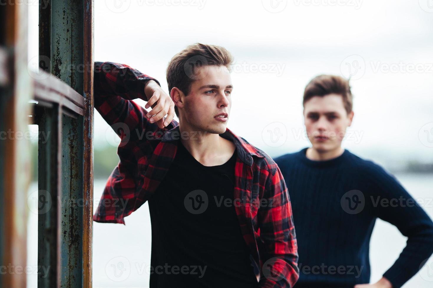 two guys stand in an abandoned building on lake photo