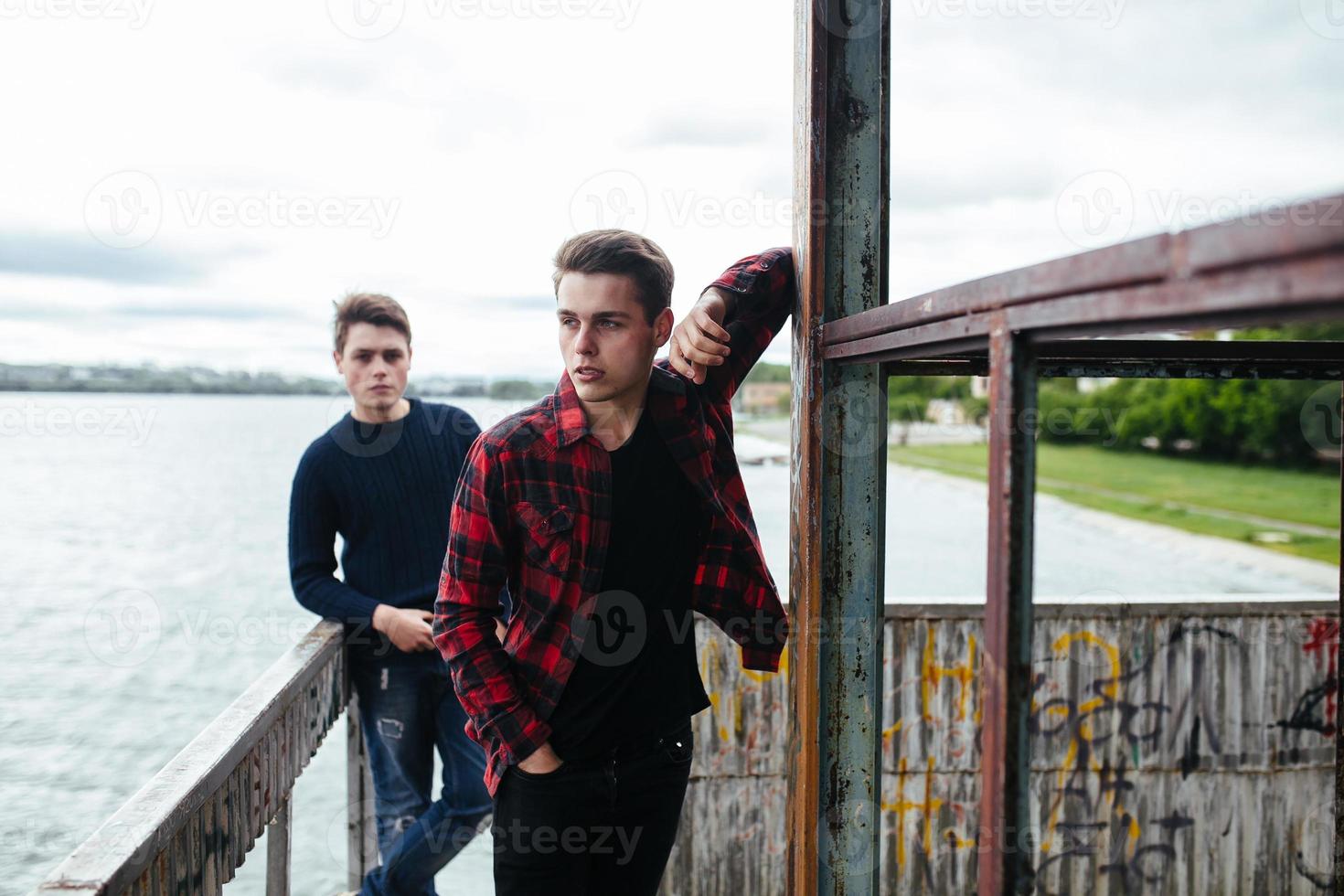 two guys stand in an abandoned building on lake photo