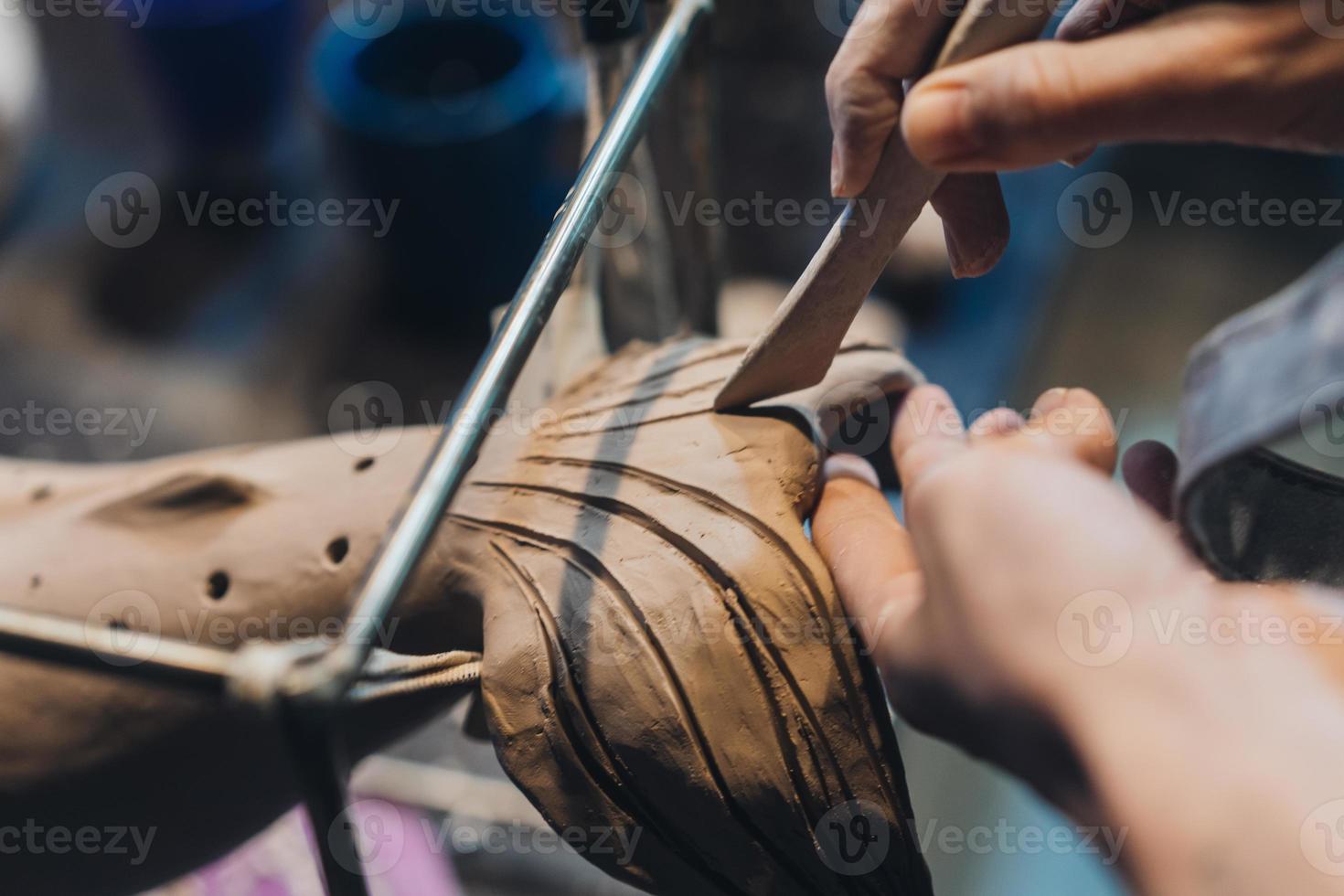 Close-up view of female hands gently handling a clay whale in workshop. photo
