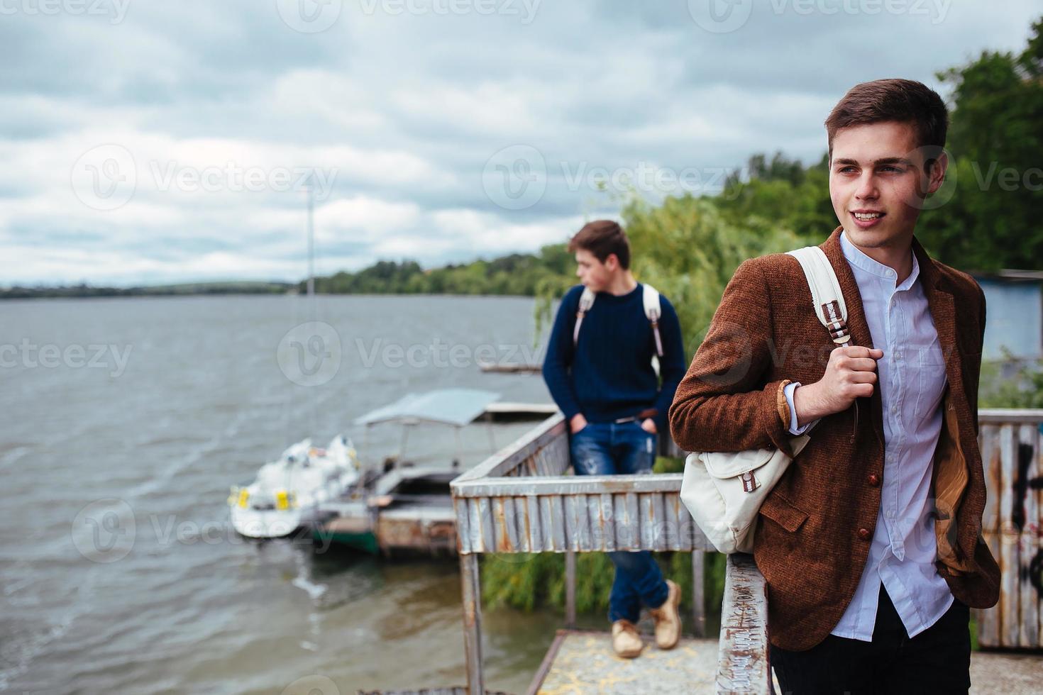 two young guys standing on a pier photo