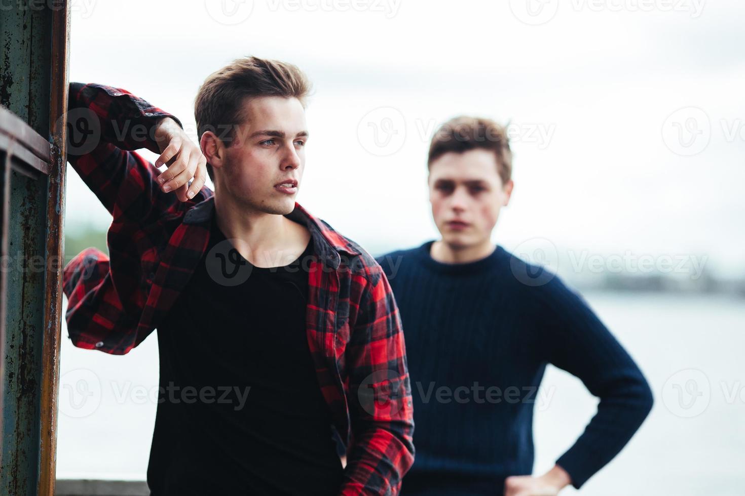 two guys stand in an abandoned building on lake photo