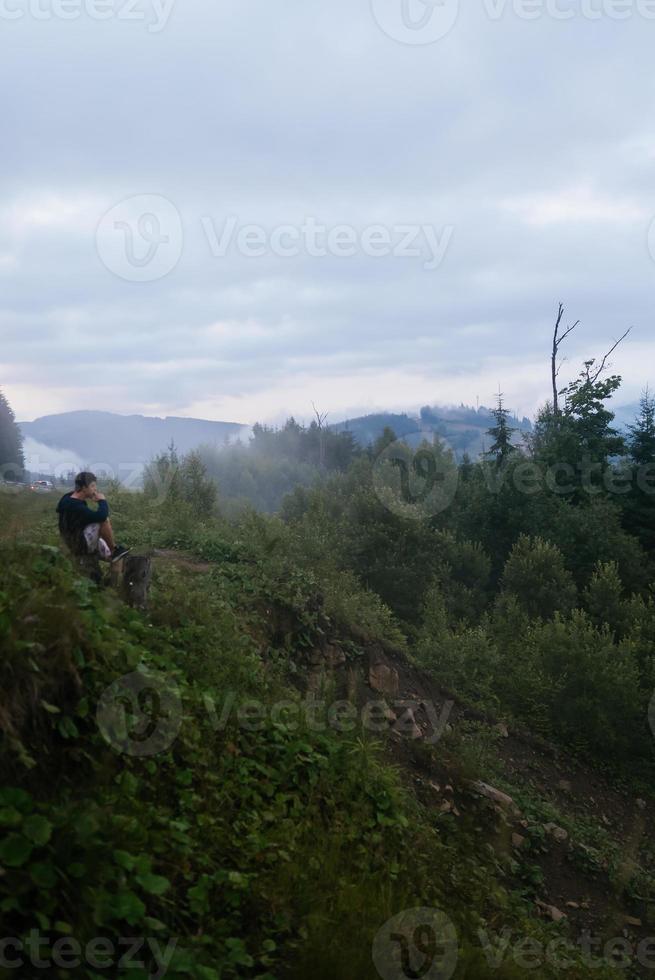 Guy top of a hill enjoying view of nature photo