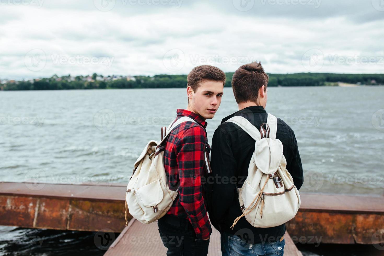 two young guys stand on the pier photo