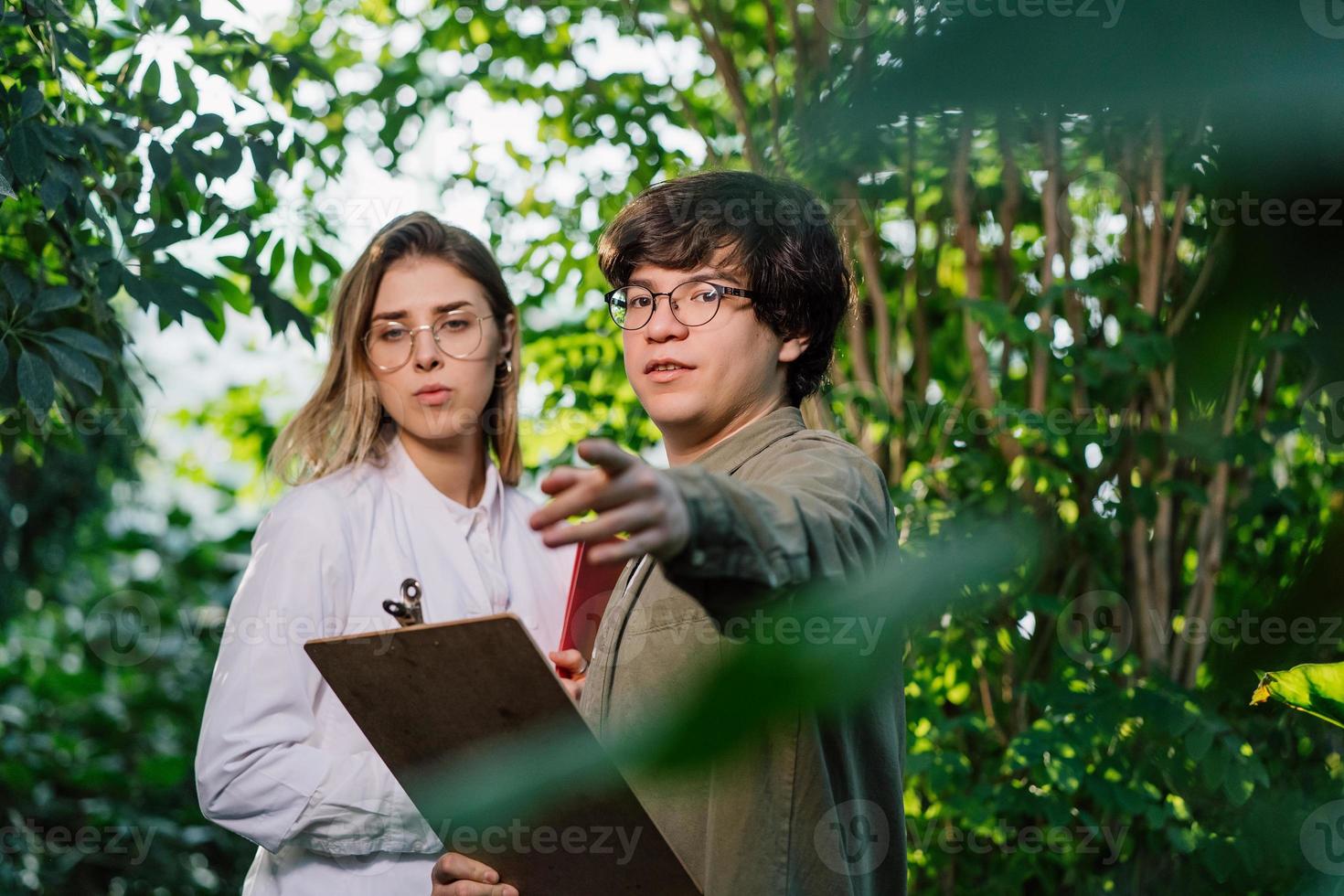 Young agricultural engineers working in greenhouse photo